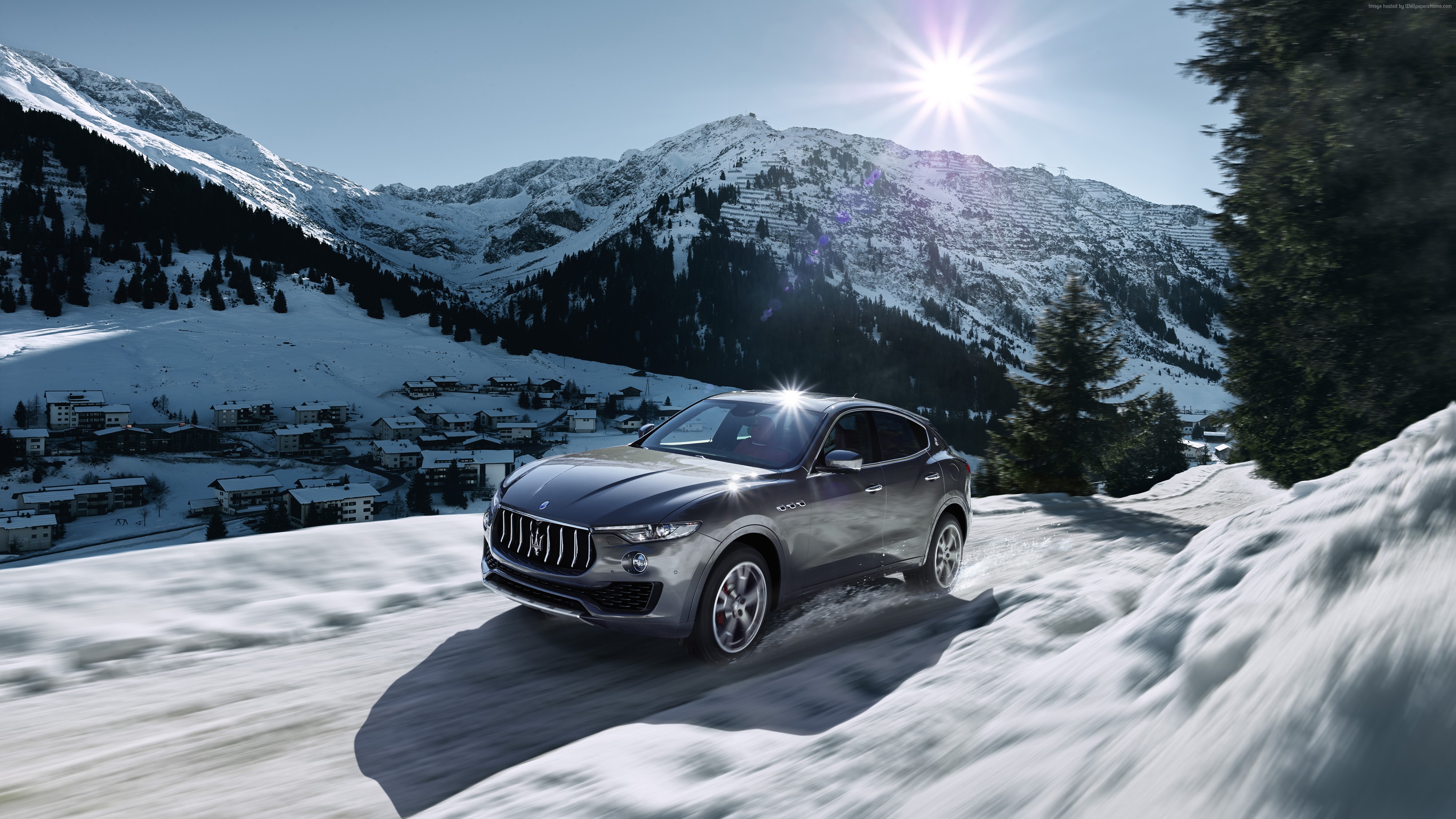 Maserati Levante driving on a snowy mountain road HD Wallpaper