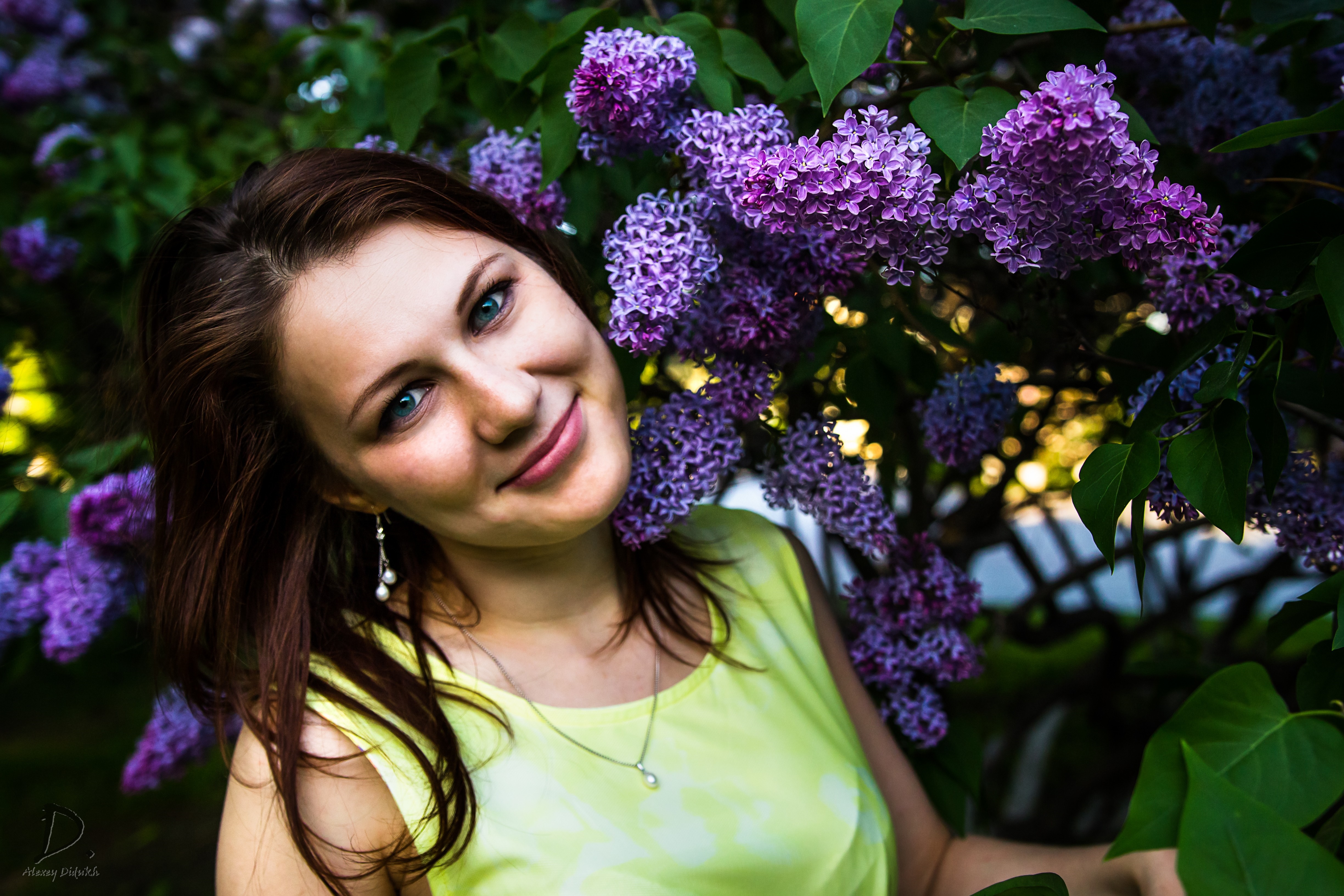 Woman with blue eyes near purple lilacs HD Wallpaper
