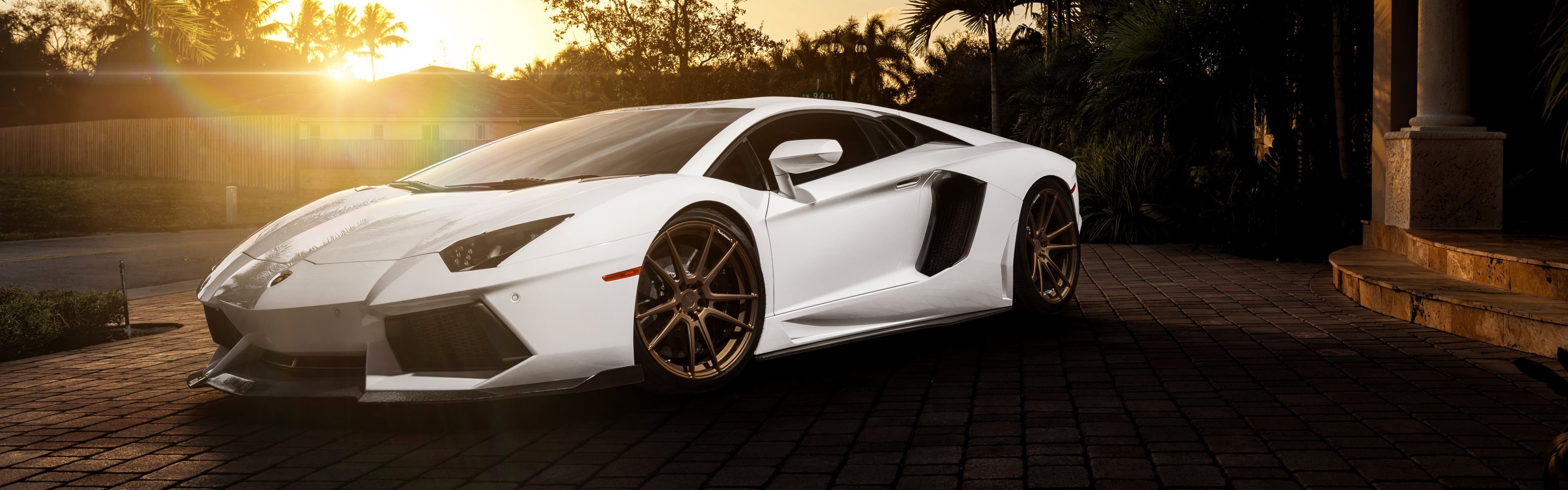 White Lamborghini Aventador parked on brick driveway HD Wallpaper