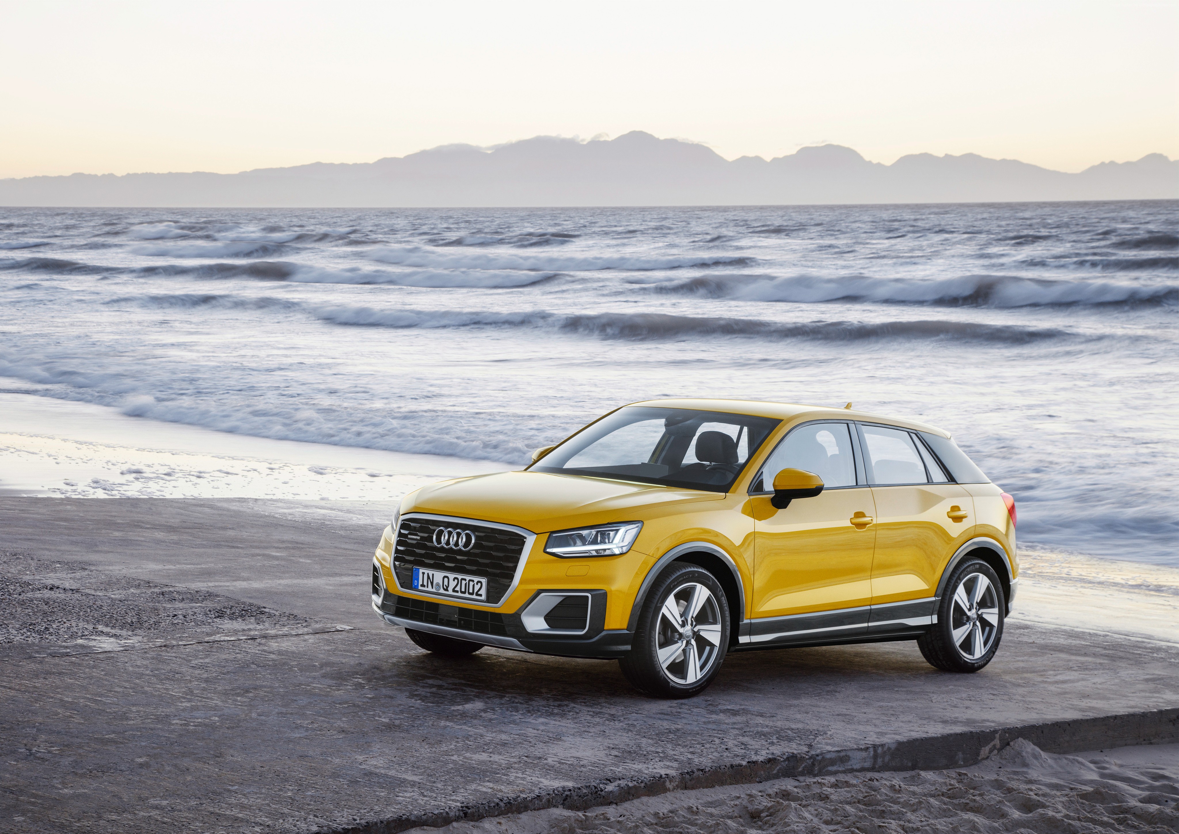 Yellow Audi Q2 crossover on a beach HD Wallpaper