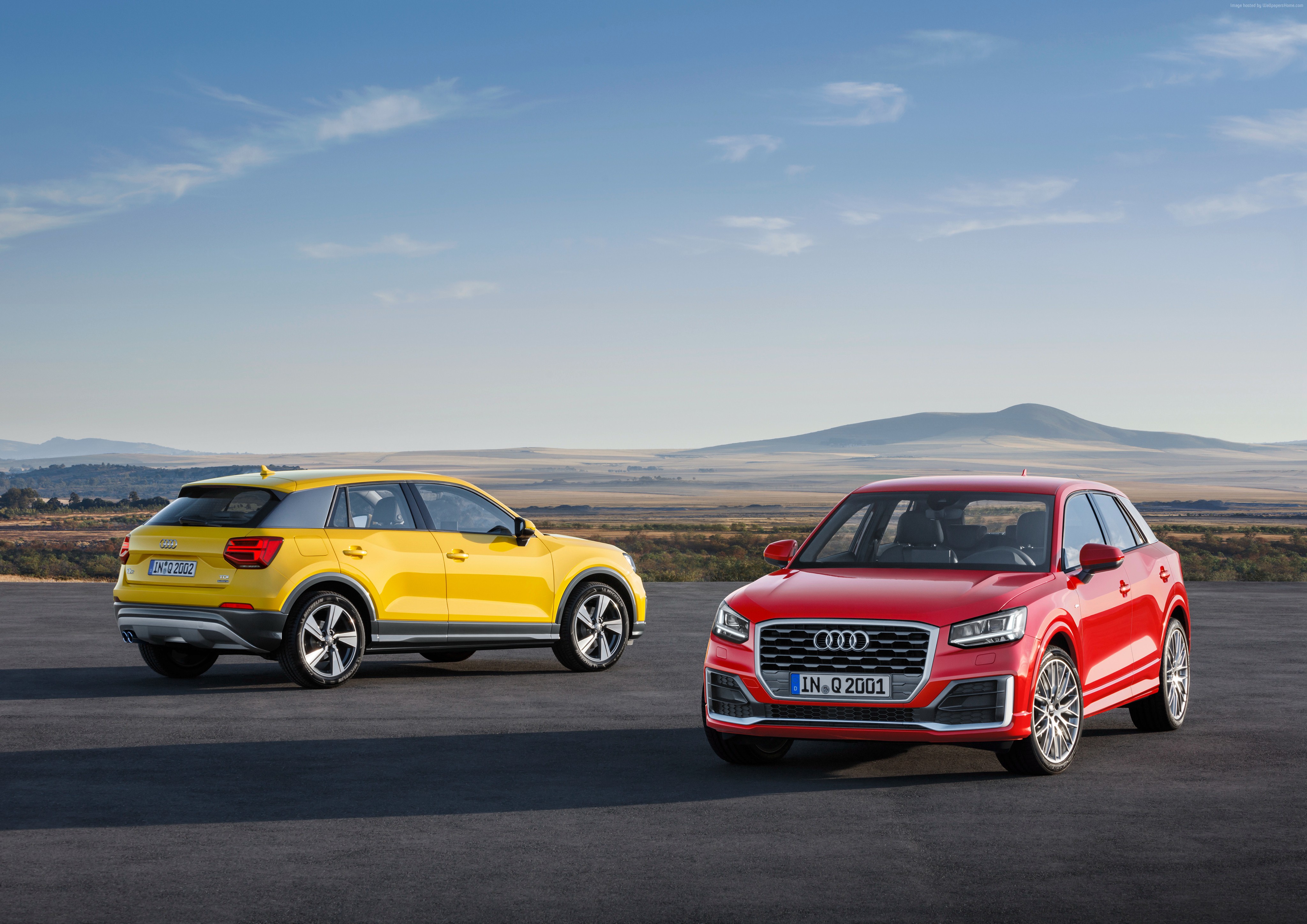 Two Audi Q2 cars, one red and one yellow, outdoors HD Wallpaper