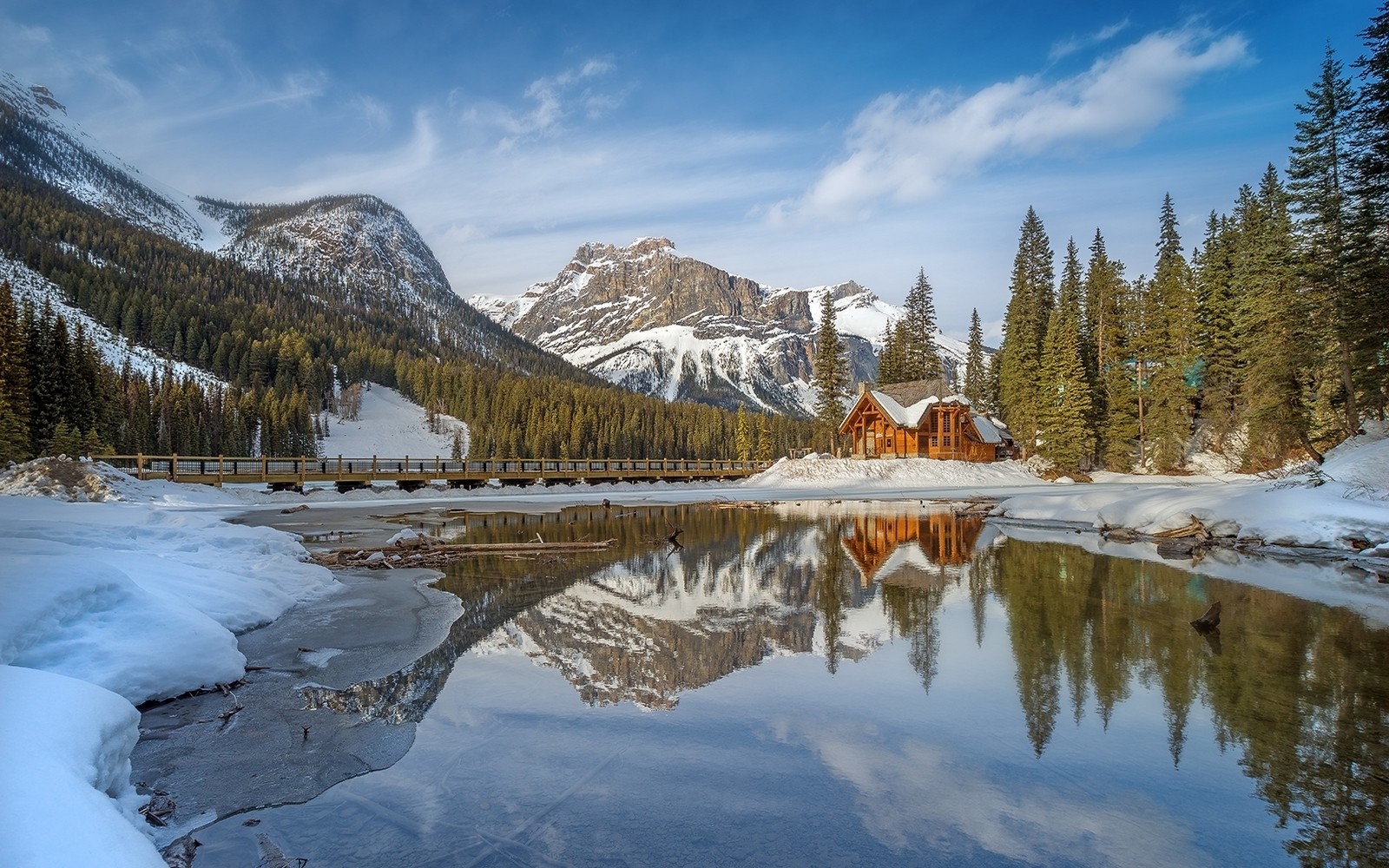 Winter cabin reflection on a lake with mountains and forest HD Wallpaper