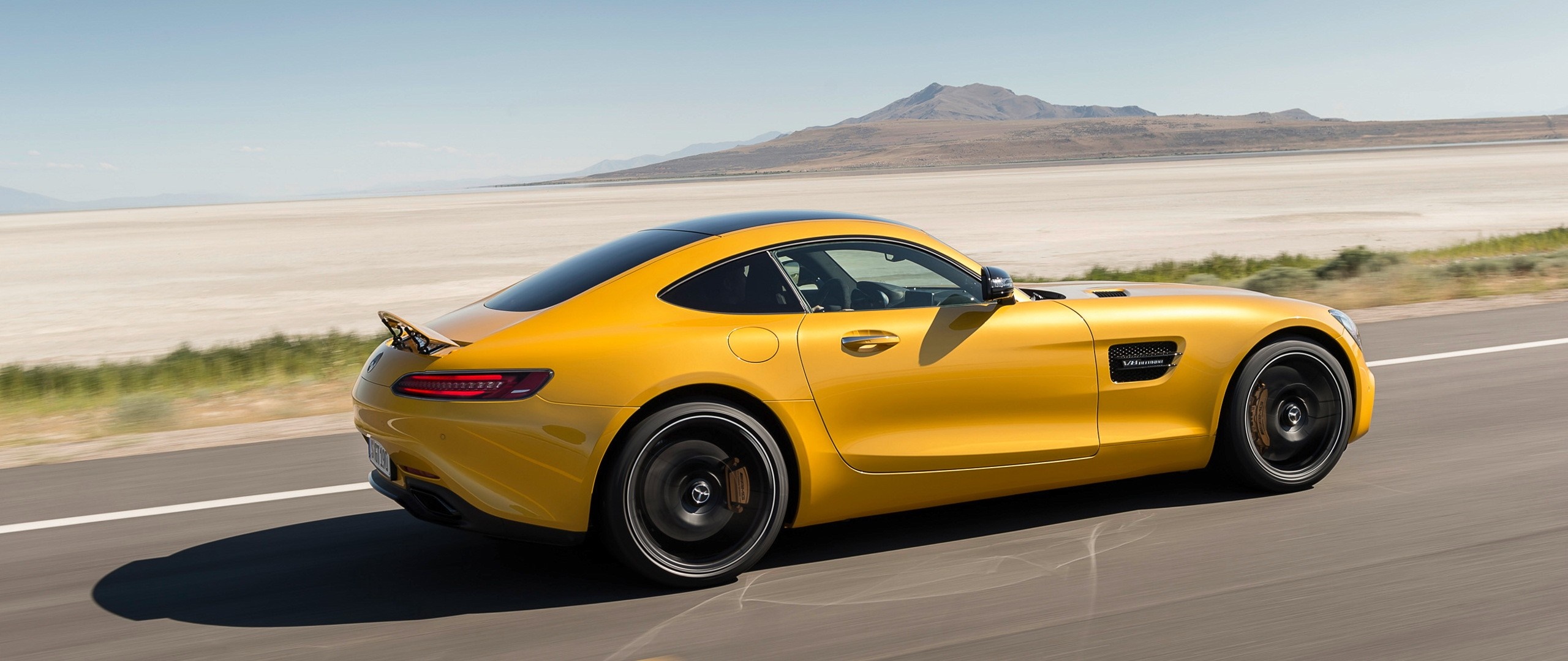 Yellow Mercedes-Benz AMG GT driving on a road HD Wallpaper