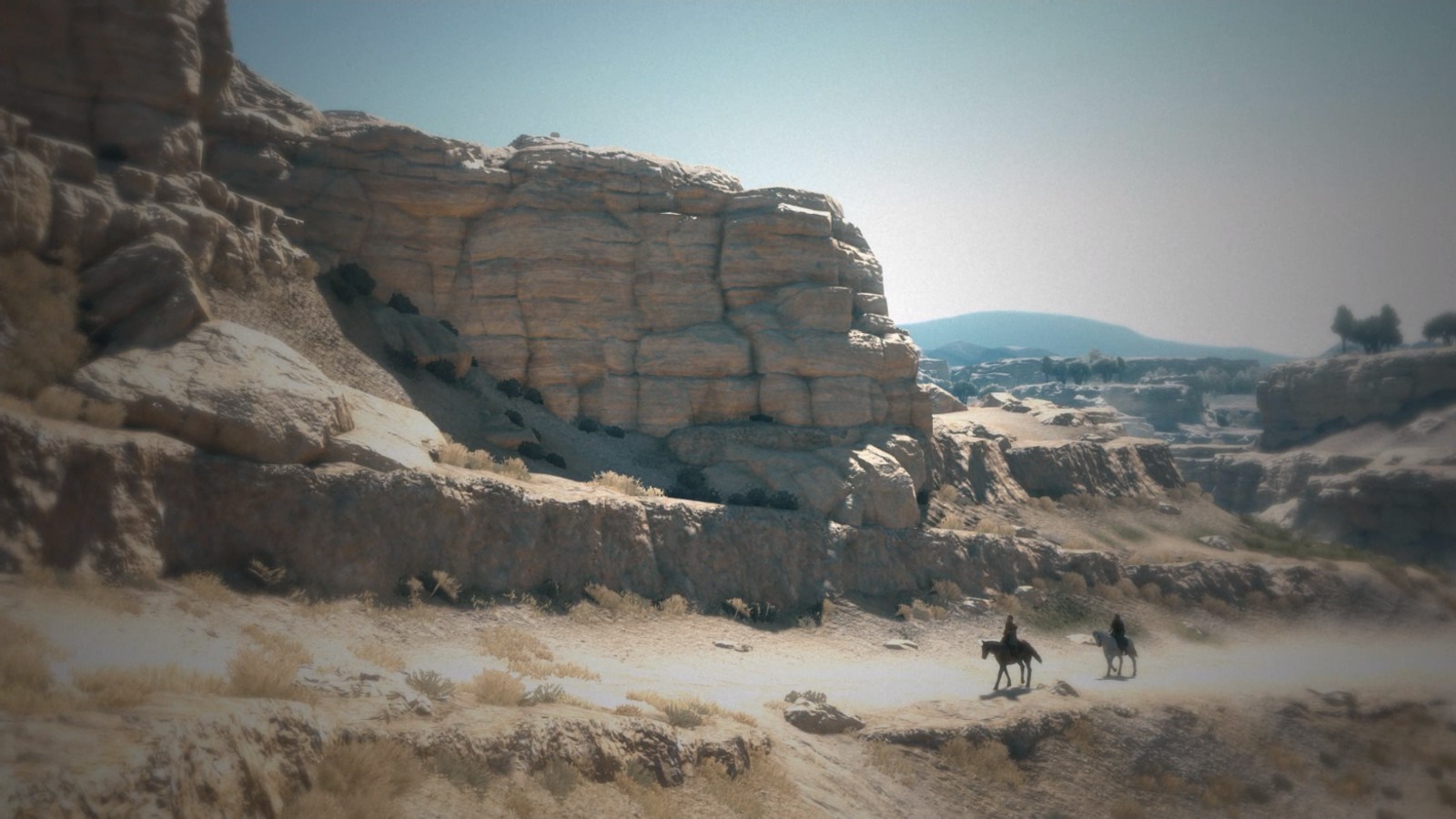 Two people on horseback in a rocky desert valley HD Wallpaper