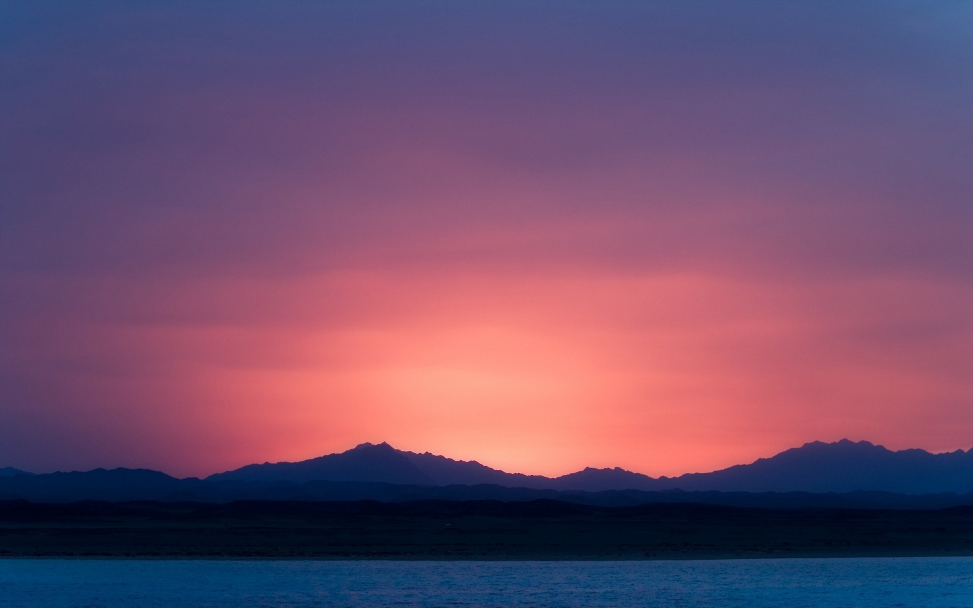 Sunset over mountains and water HD Wallpaper