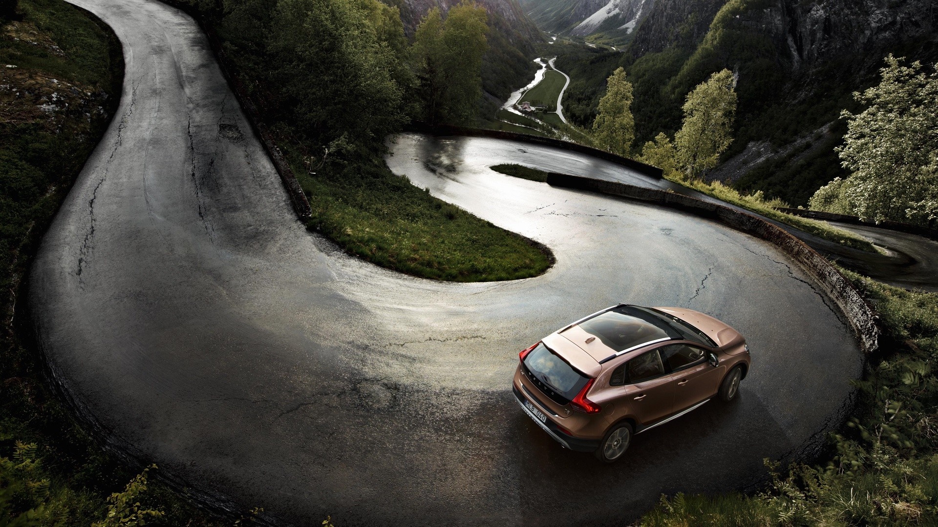 Volvo car driving on a winding mountain road HD Wallpaper