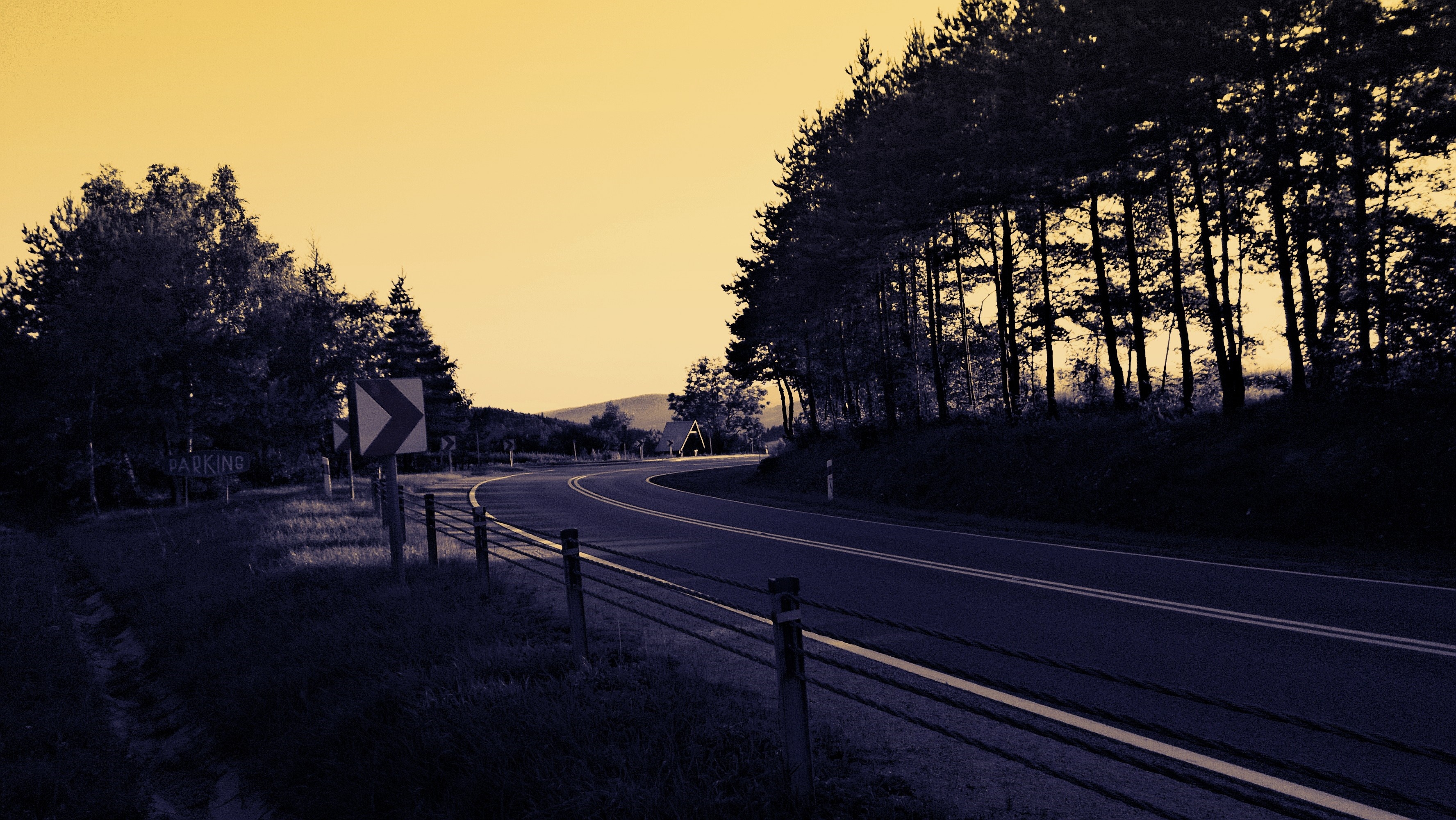 Curving road through trees with parking sign HD Wallpaper