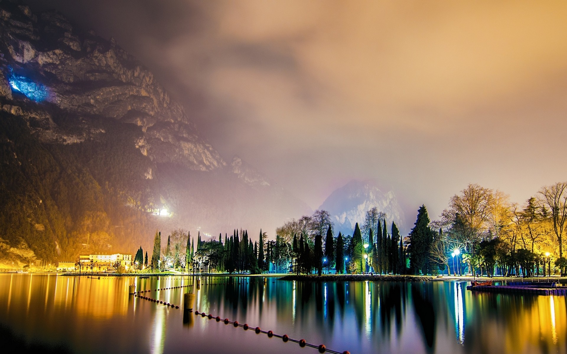 Night lake reflection with mountains and city lights HD Wallpaper