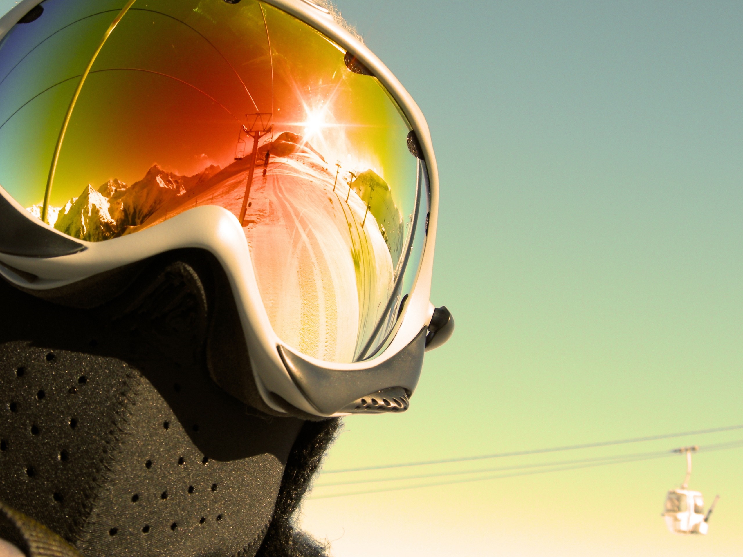 Close-up of ski goggles reflecting a mountain landscape with ski lift HD Wallpaper