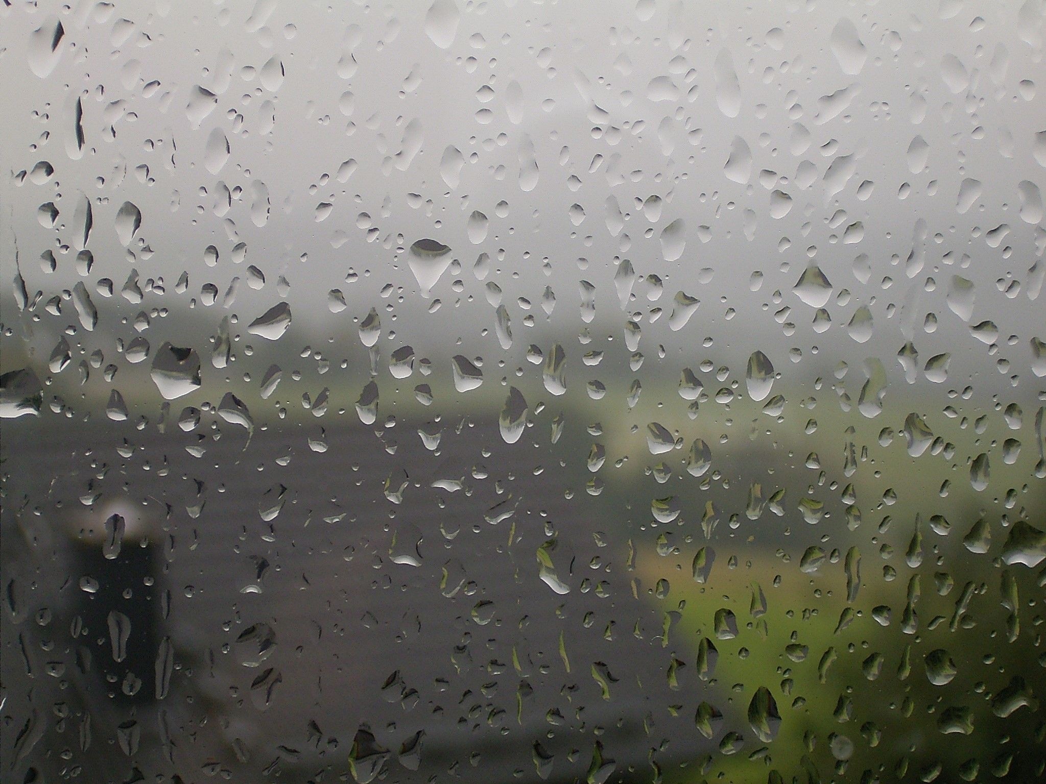 Raindrops on a window pane with blurred background HD Wallpaper