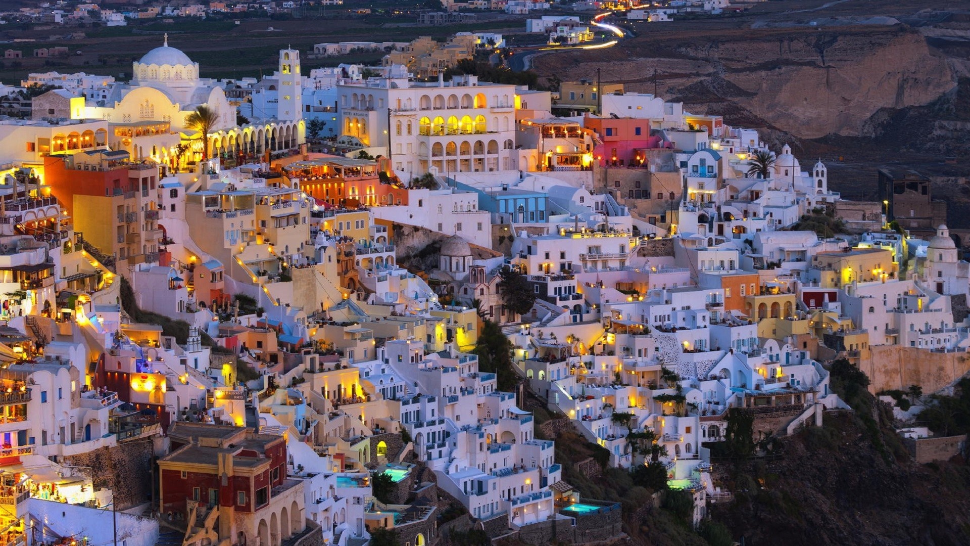 Santorini cityscape with illuminated buildings at dusk HD Wallpaper