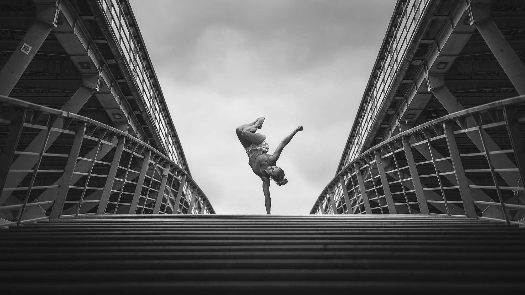 Woman performing a handstand on a bridge HD Wallpaper