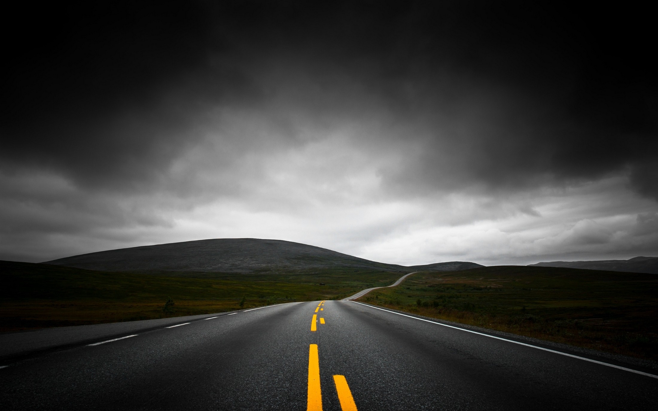 Road through a dark, cloudy landscape HD Wallpaper