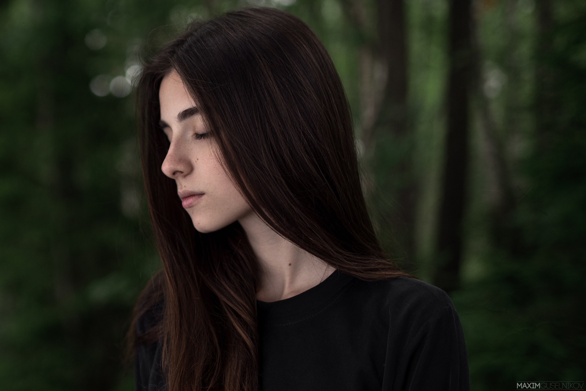 Portrait of a young woman with long brown hair in a forest HD Wallpaper