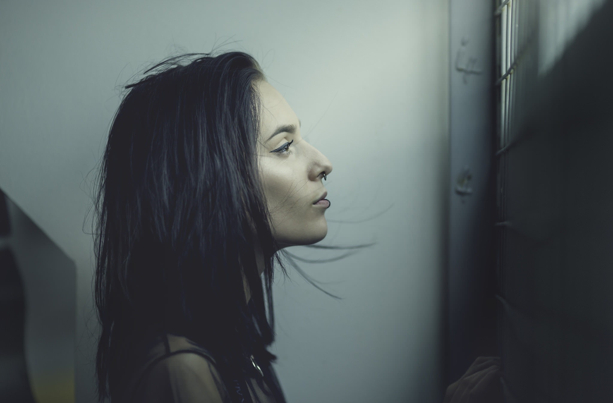 Woman with dark hair and nose rings in profile HD Wallpaper