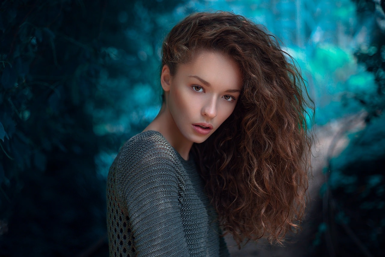 Woman with curly brown hair in a grey sweater HD Wallpaper