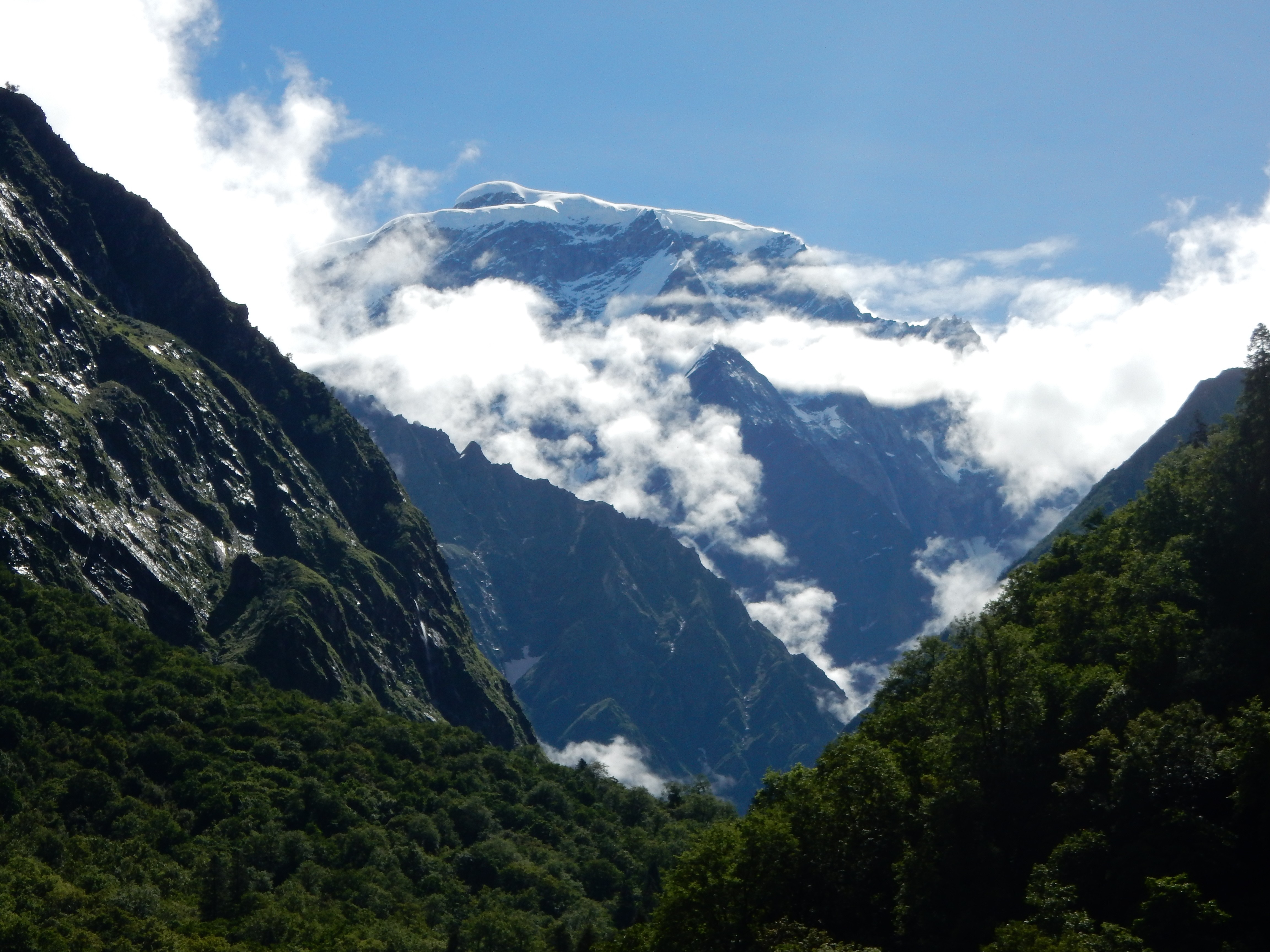 Snow-capped Himalayas mountains with clouds and green valley HD Wallpaper