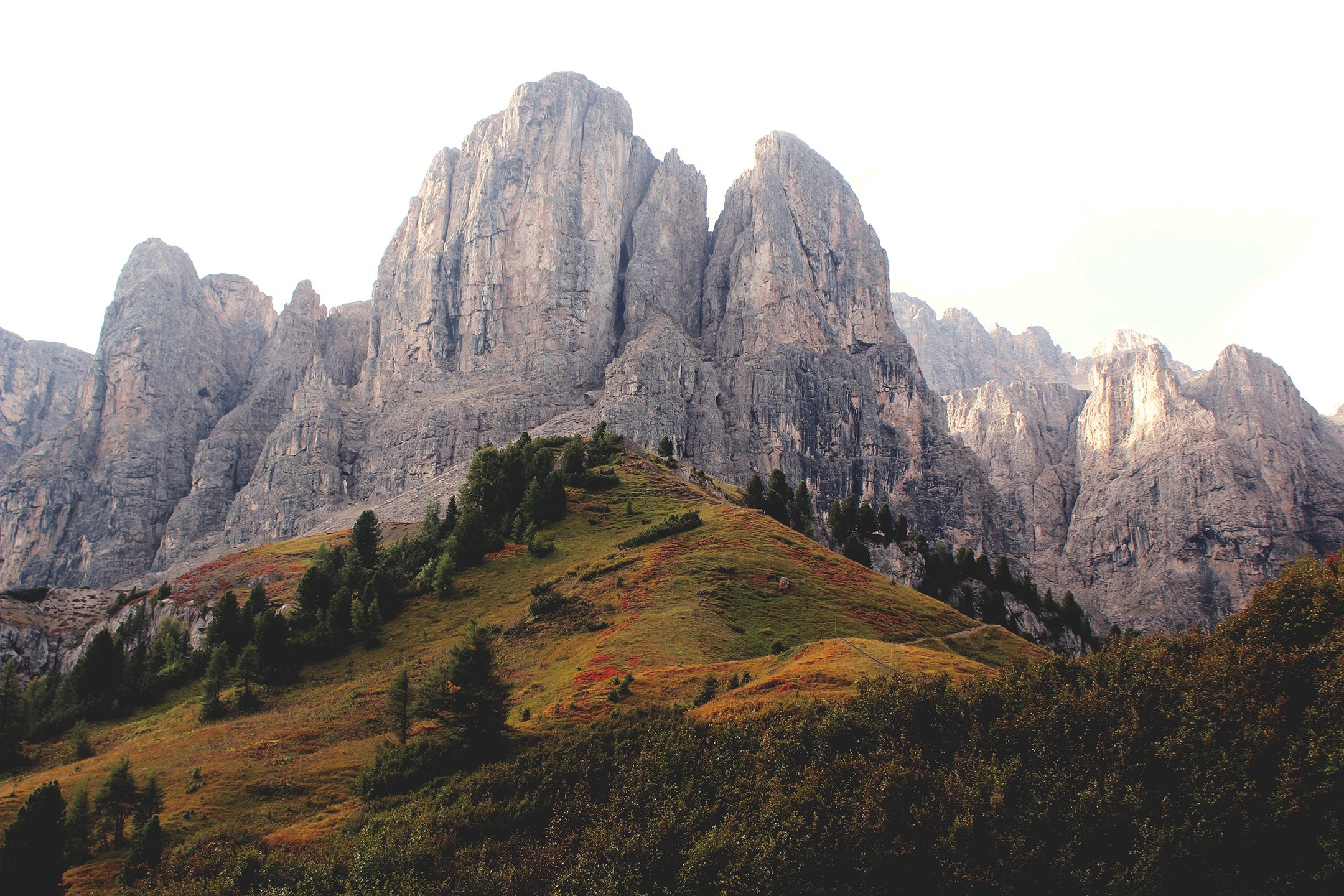 Rocky mountain range with green and brown hills HD Wallpaper