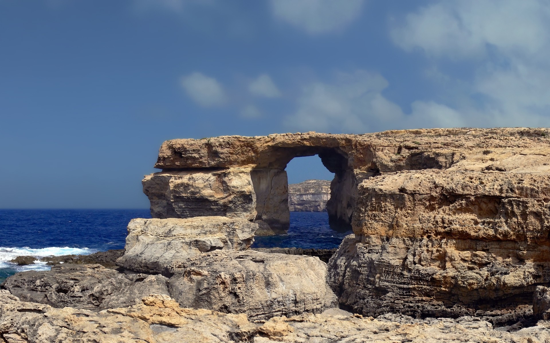 Natural rock arch over the sea on a rocky coast HD Wallpaper