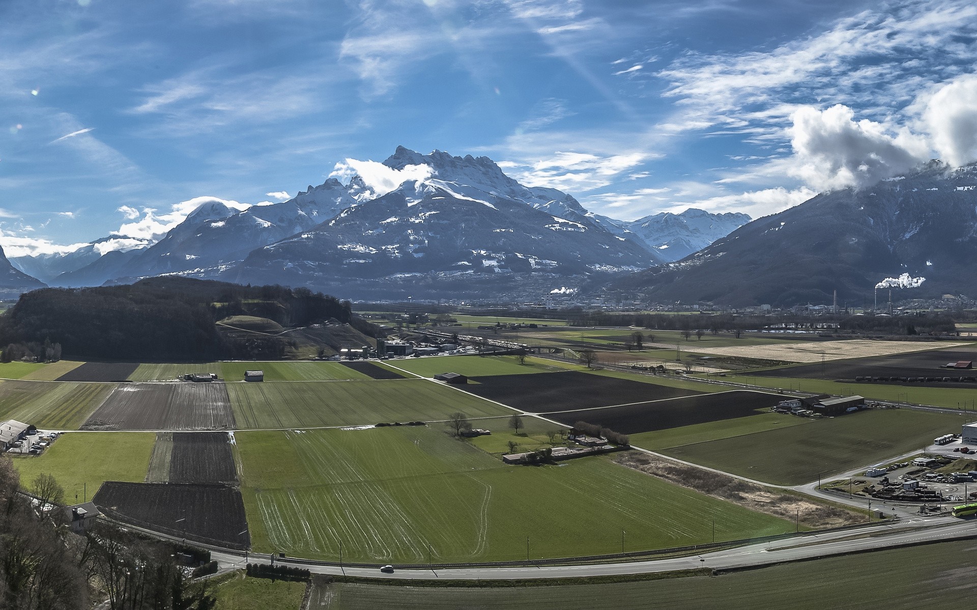 Aerial view of agricultural fields and snow-capped mountains HD Wallpaper