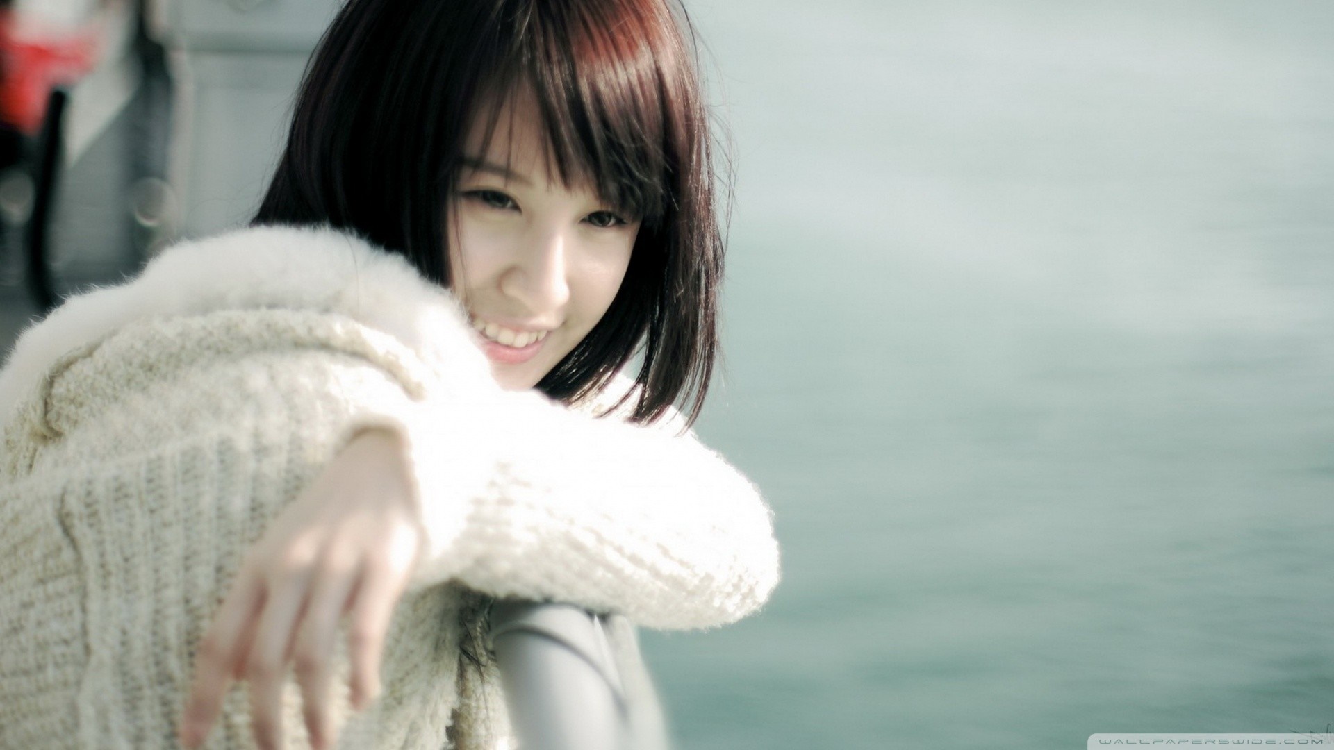 Young Asian woman in a white sweater smiling HD Wallpaper