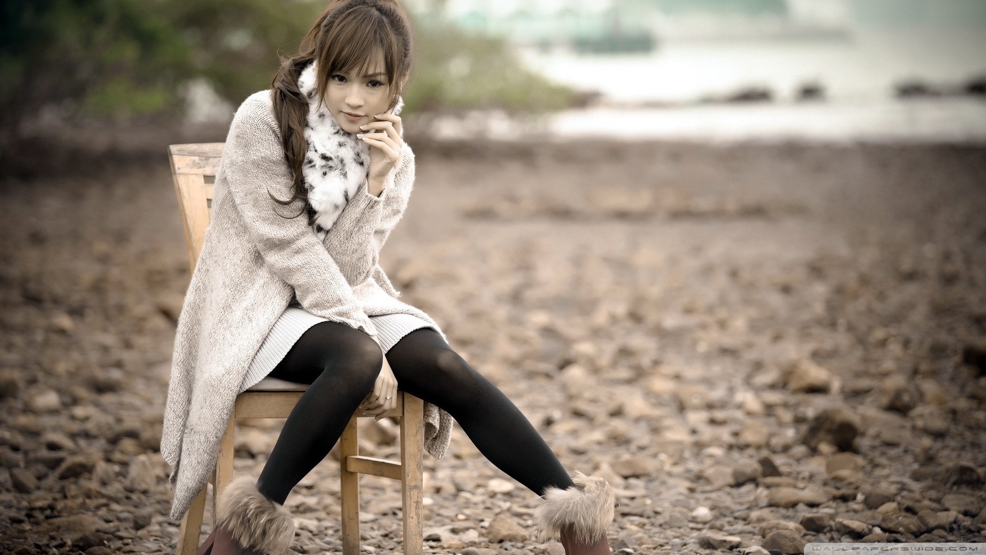Asian woman sitting on a chair on a rocky shore HD Wallpaper