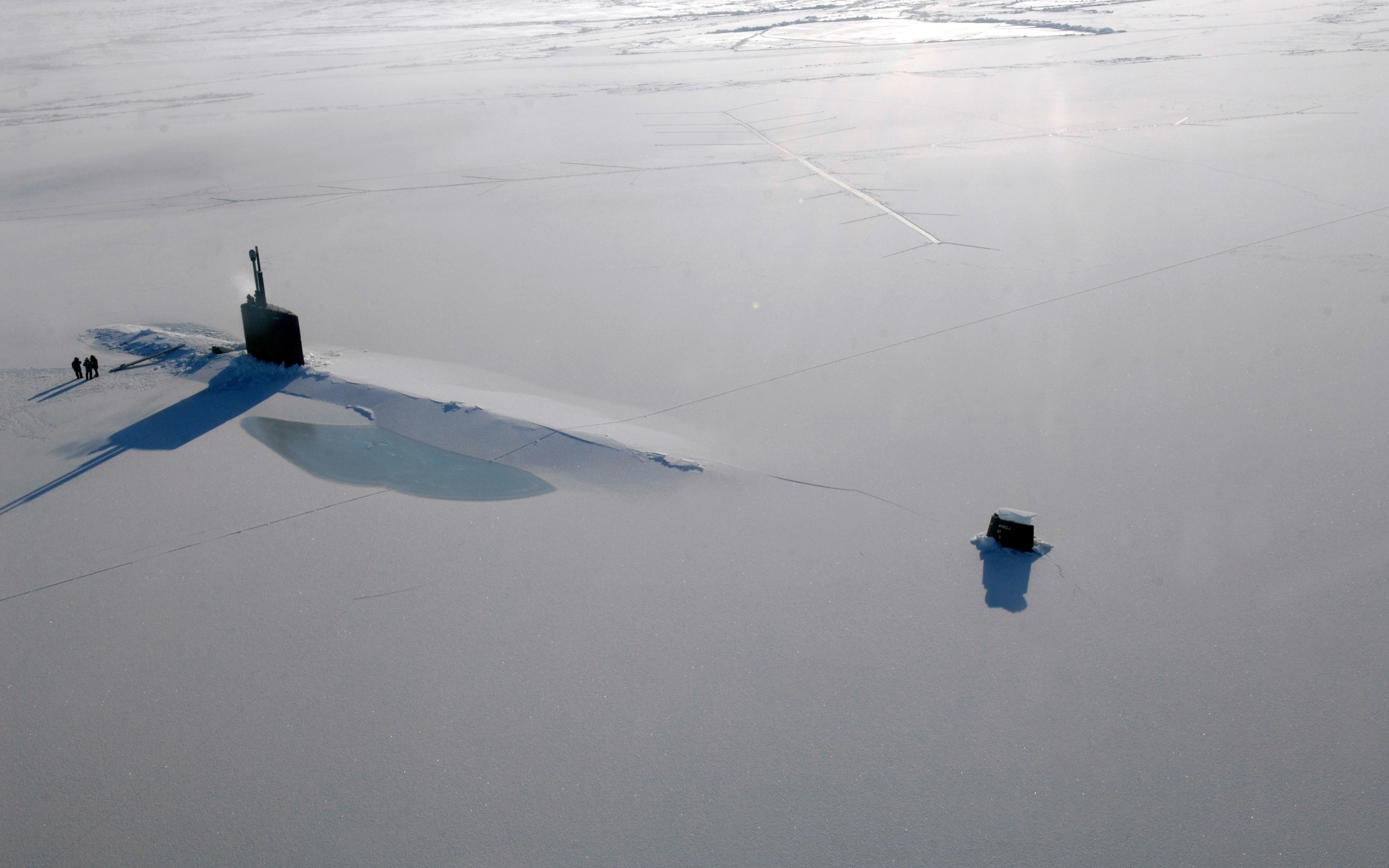 Submarine surfaced in Arctic ice with small structure nearby HD Wallpaper