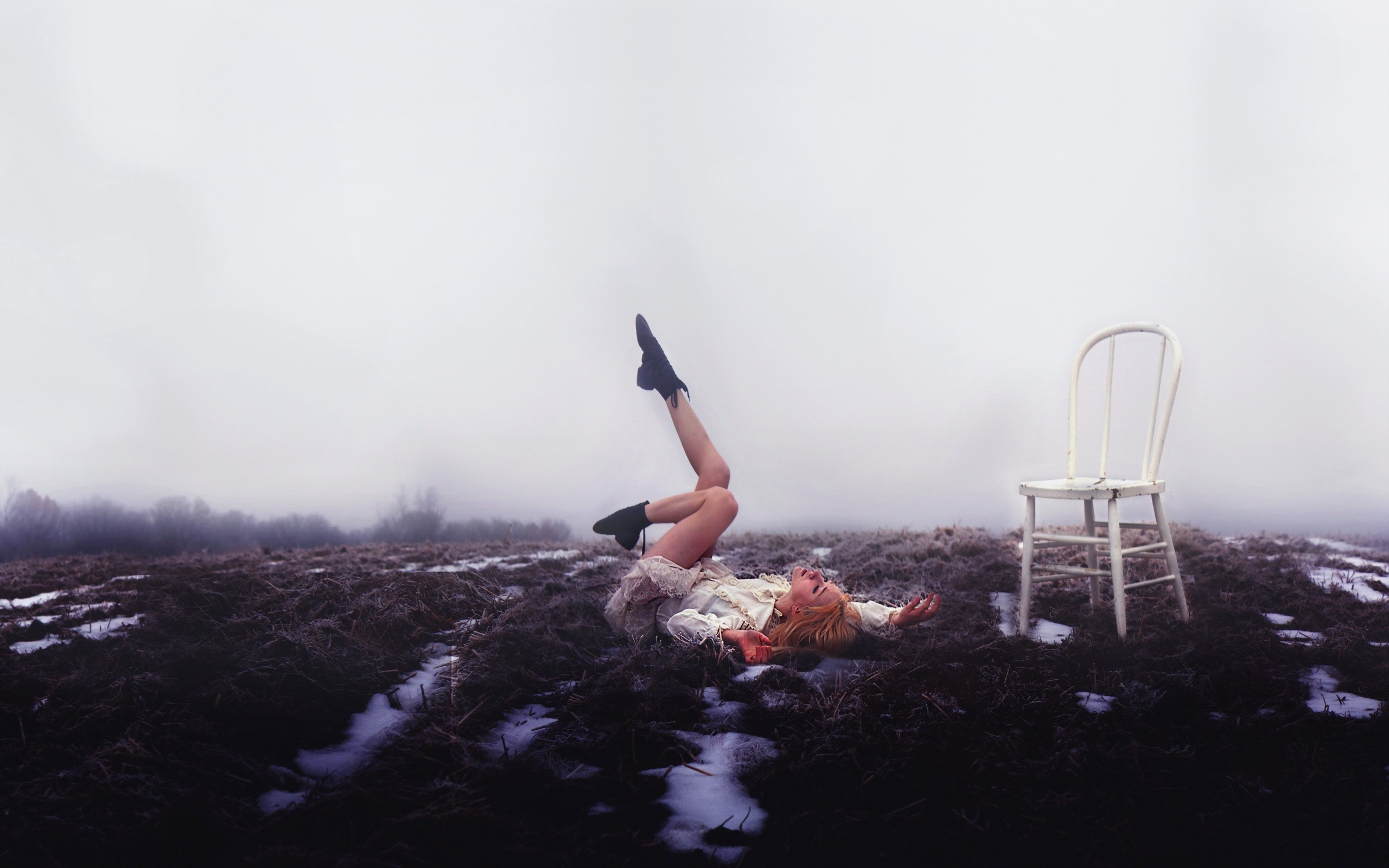 Woman lying in a field with a chair HD Wallpaper