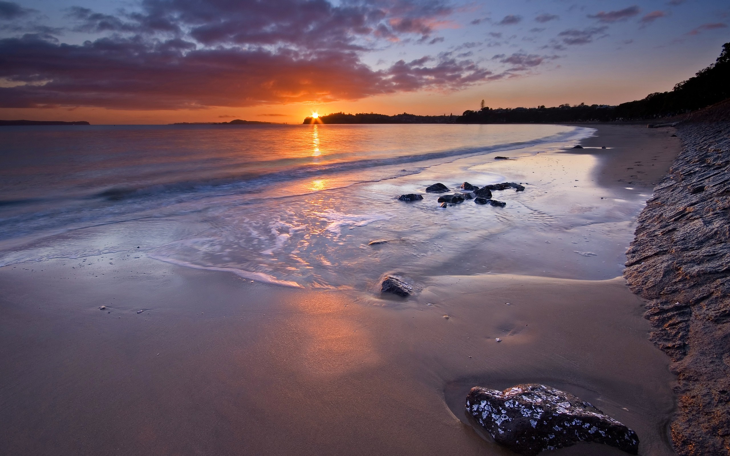 Sunset over the ocean with waves on a sandy beach HD Wallpaper