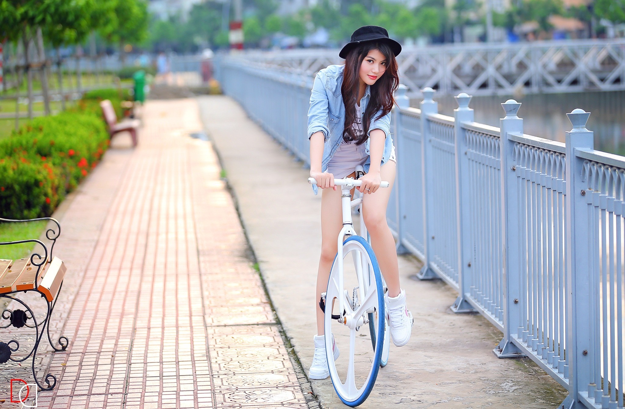 Asian woman in hat riding a bicycle outdoors HD Wallpaper