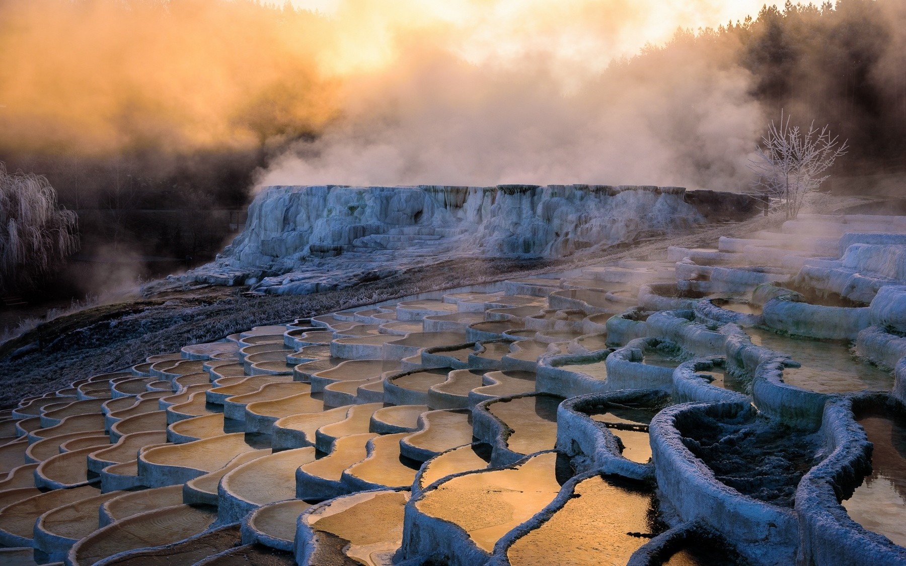 Terraced hot springs with steam at sunrise HD Wallpaper