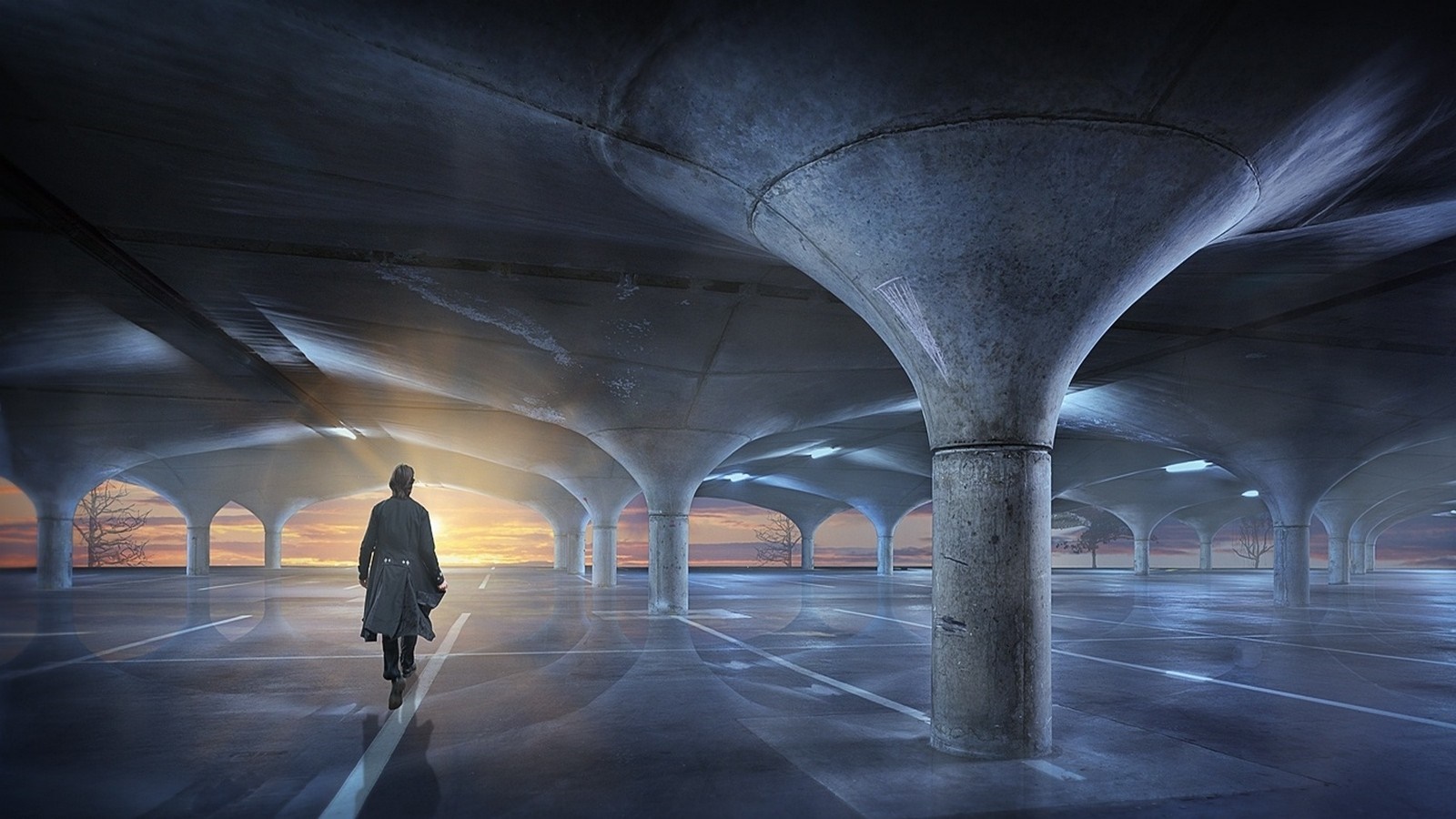 Person walking in an empty concrete parking lot at sunset HD Wallpaper