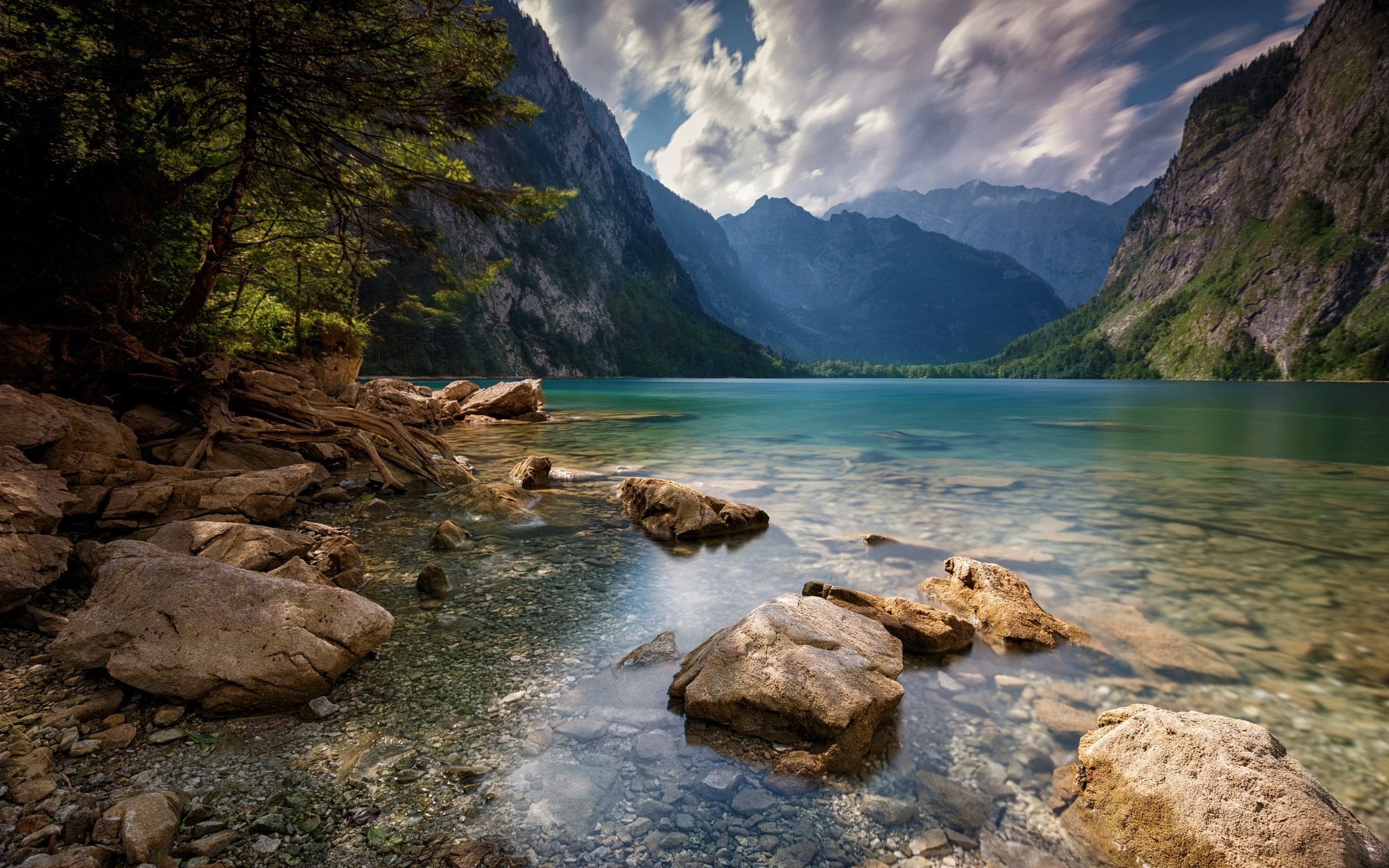 Serene Mountain Lake with Rocky Shore and Cloudy Sky HD Wallpaper