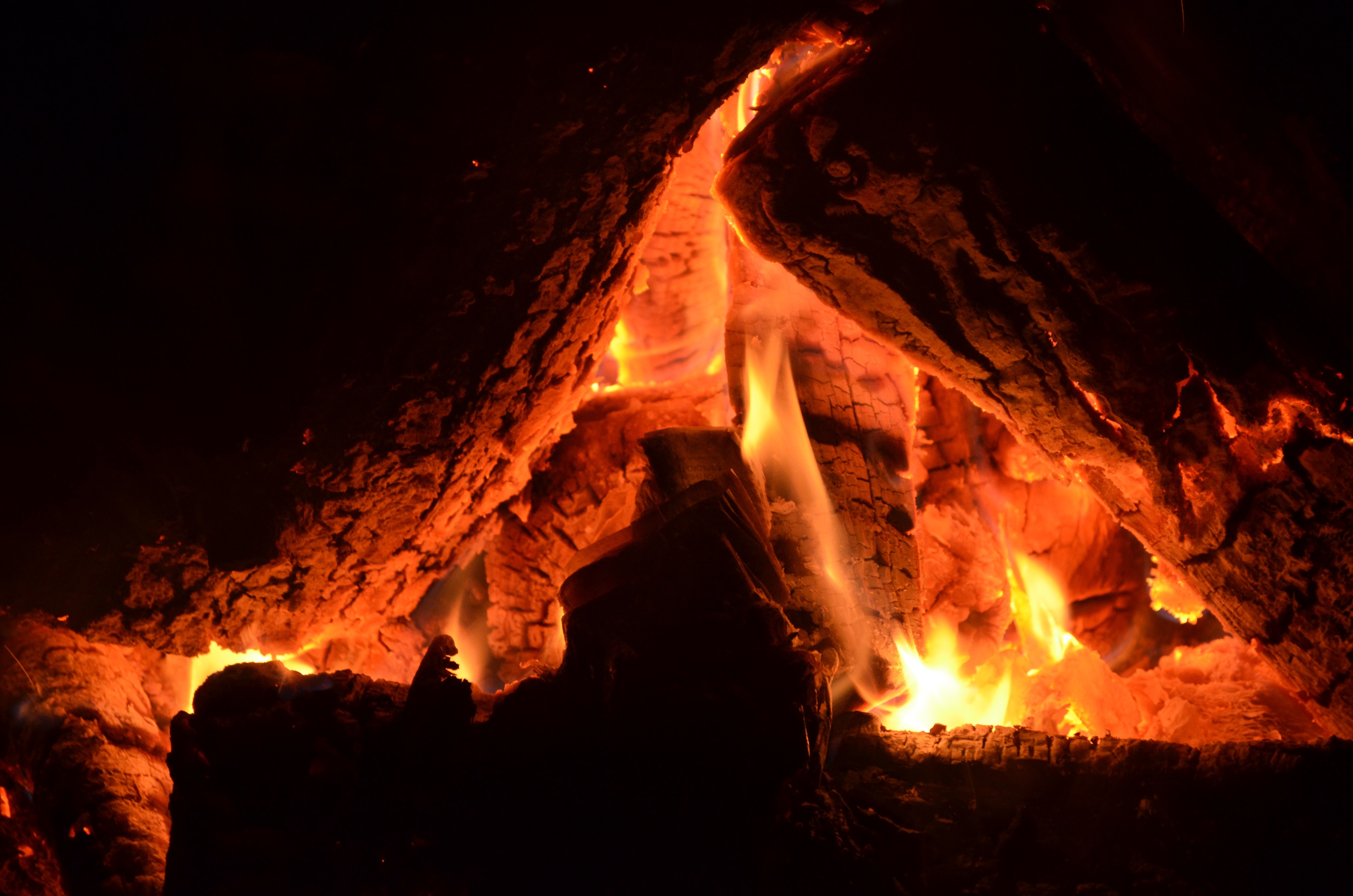 Close-up of a bonfire with glowing embers and flames HD Wallpaper