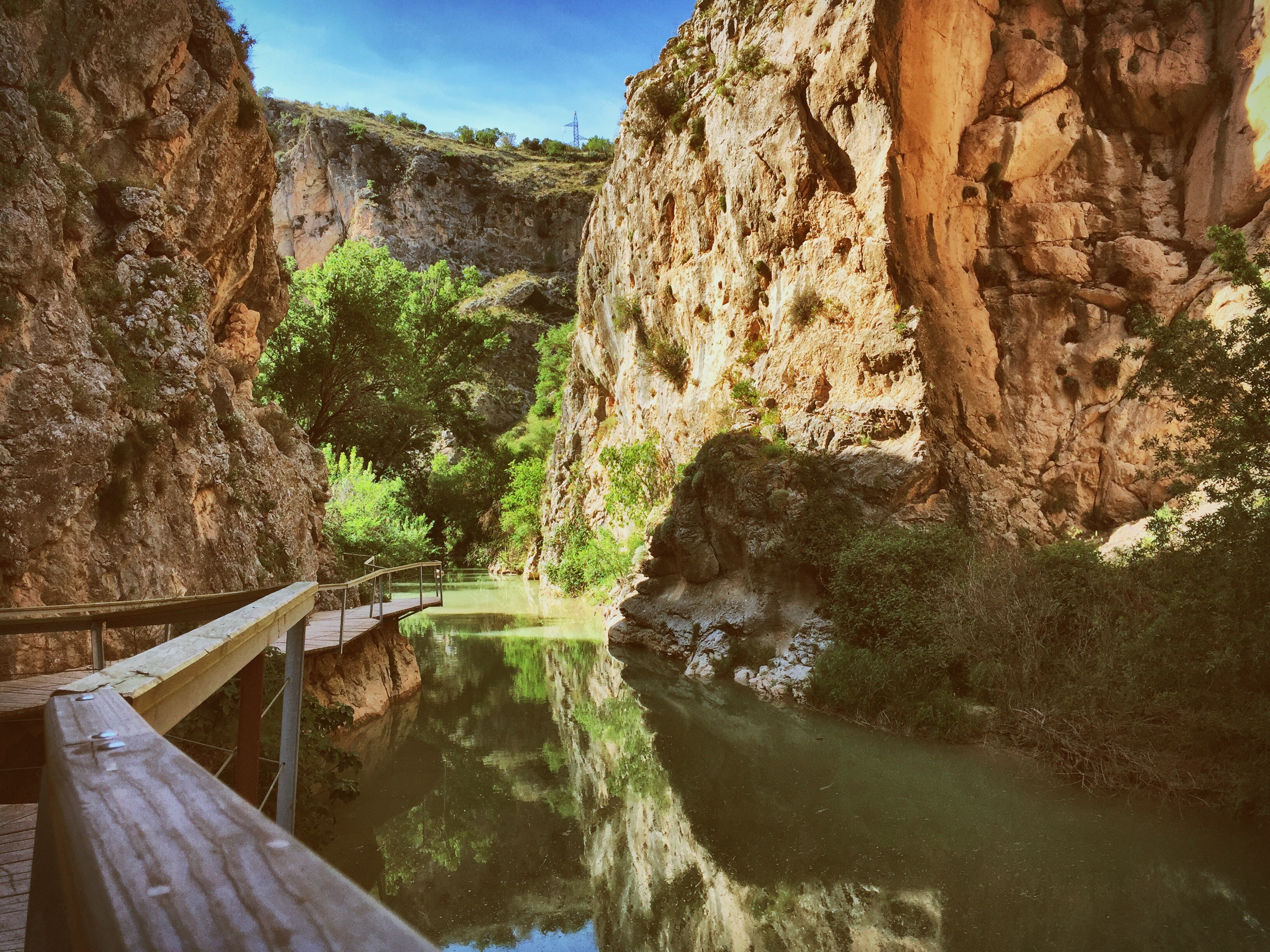 Wooden walkway along a river in a rocky canyon HD Wallpaper
