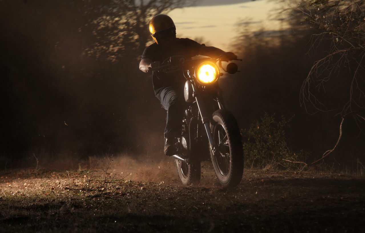 Motorcyclist in a yellow helmet riding a motorcycle at dusk HD Wallpaper