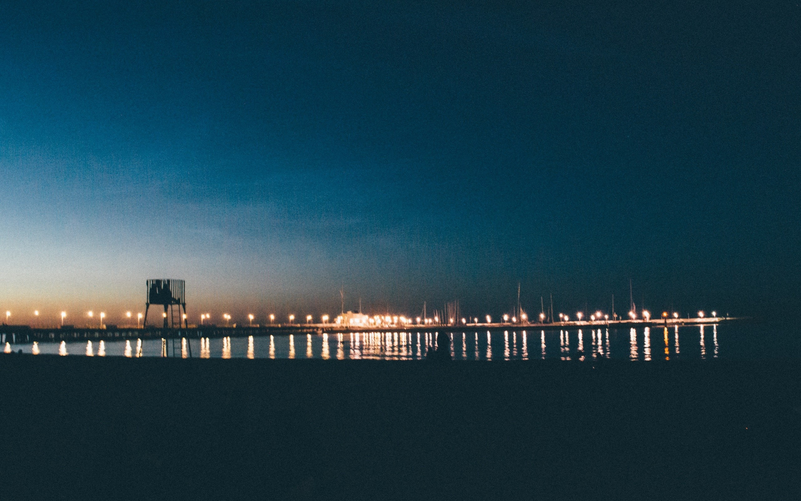 Pier with lights at dusk over the sea HD Wallpaper