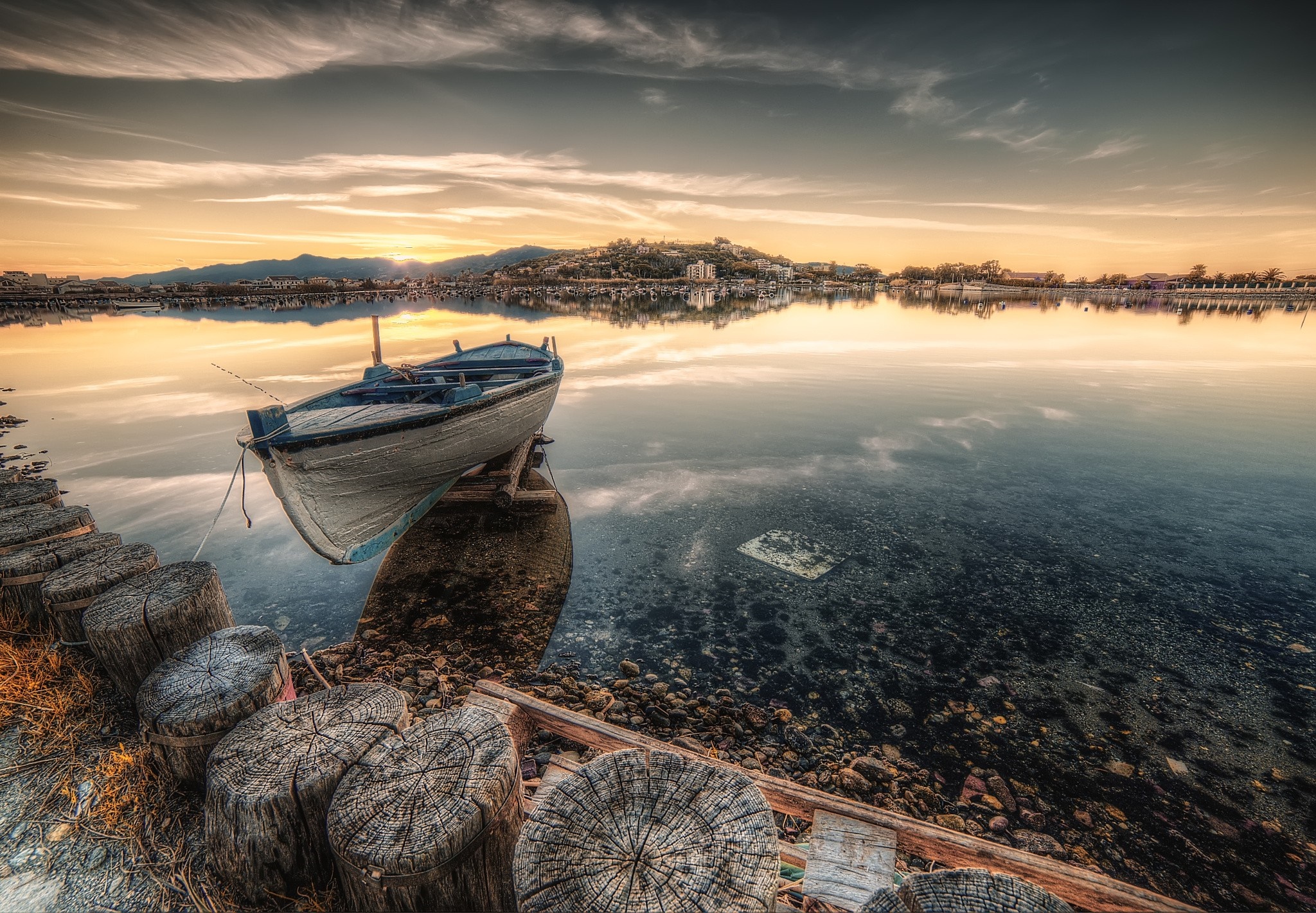 Boat on a calm lake at sunset with reflections HD Wallpaper