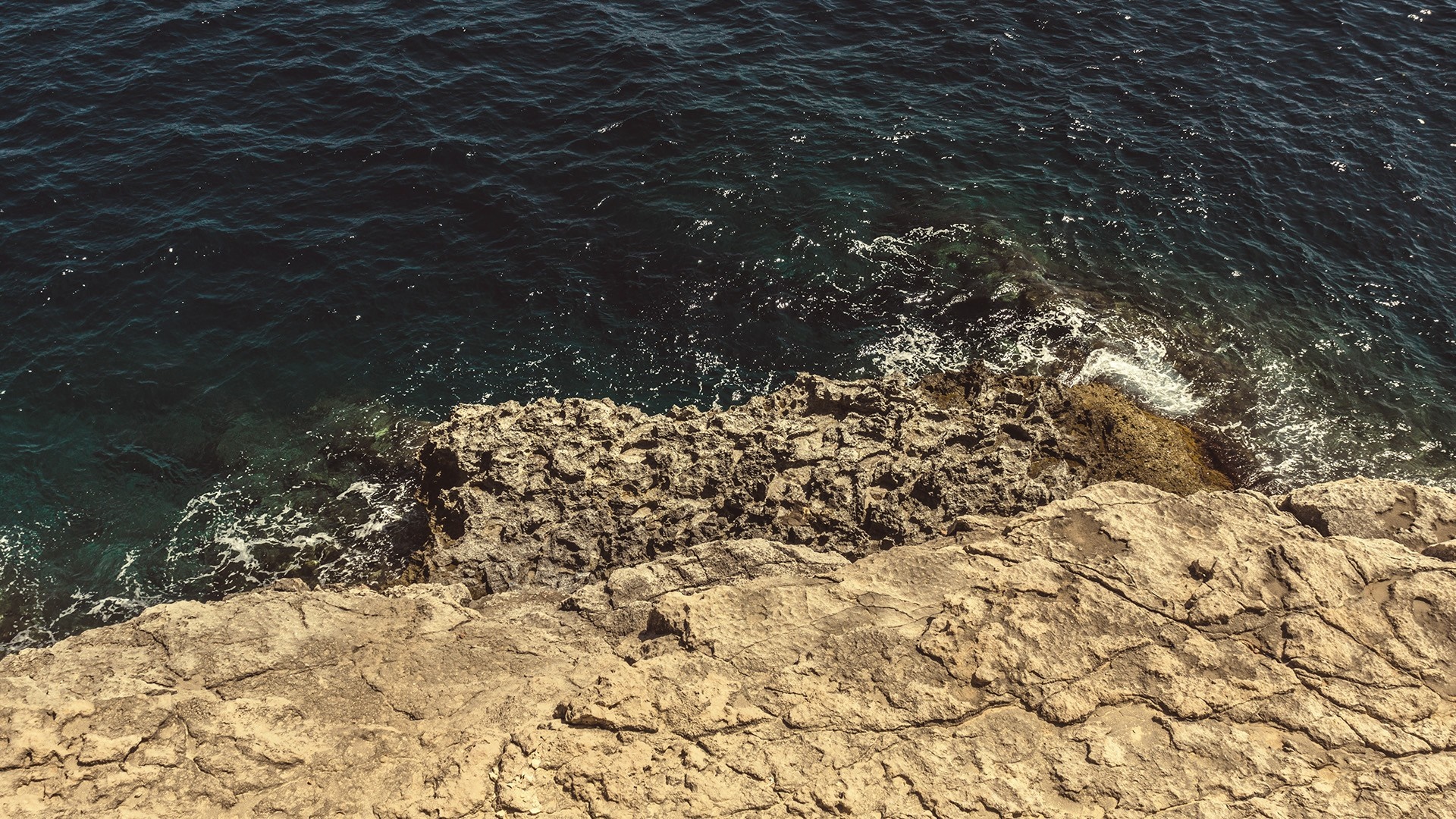 Rocky coast with dark blue ocean waves HD Wallpaper