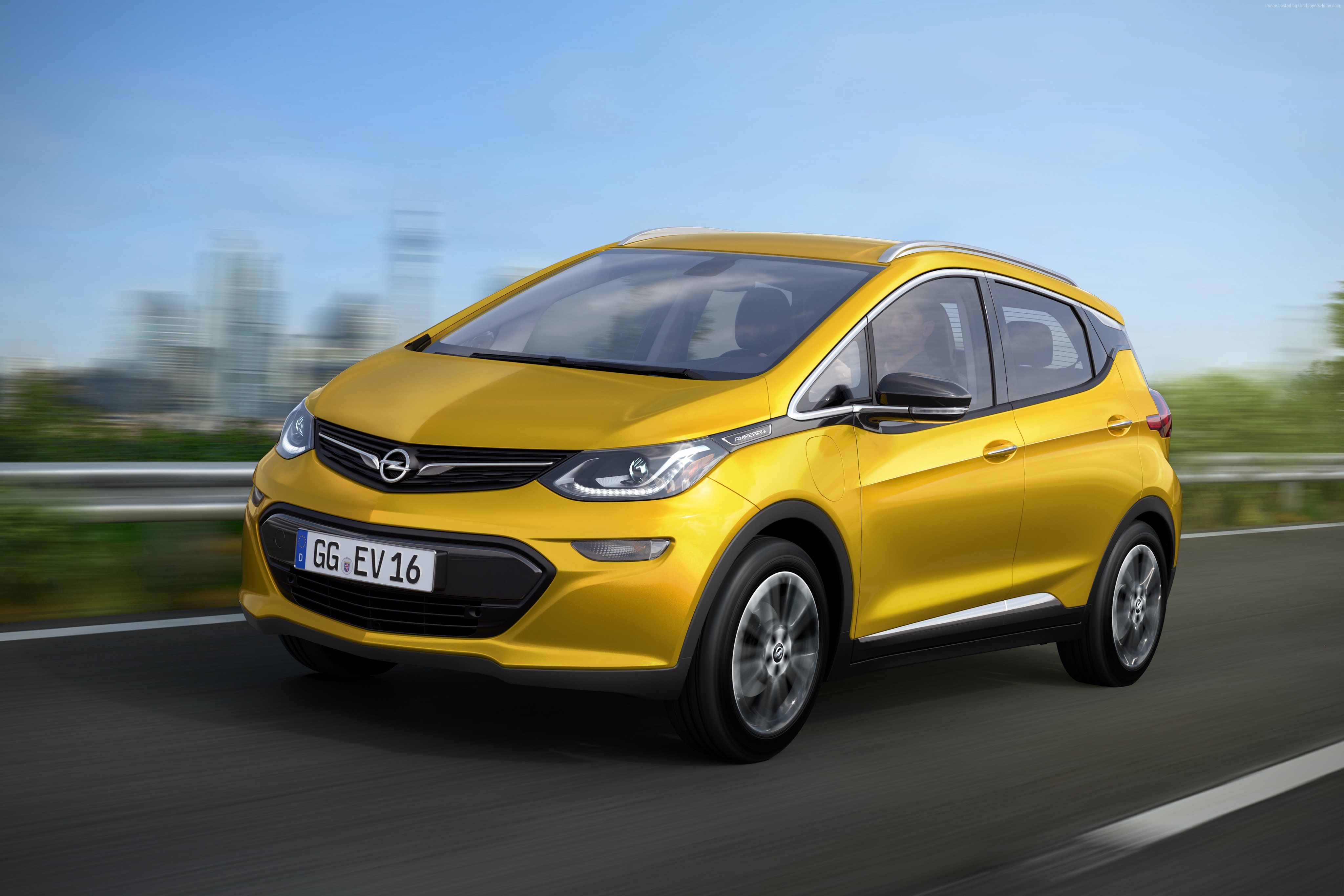Yellow Opel Ampera-e driving on a road HD Wallpaper