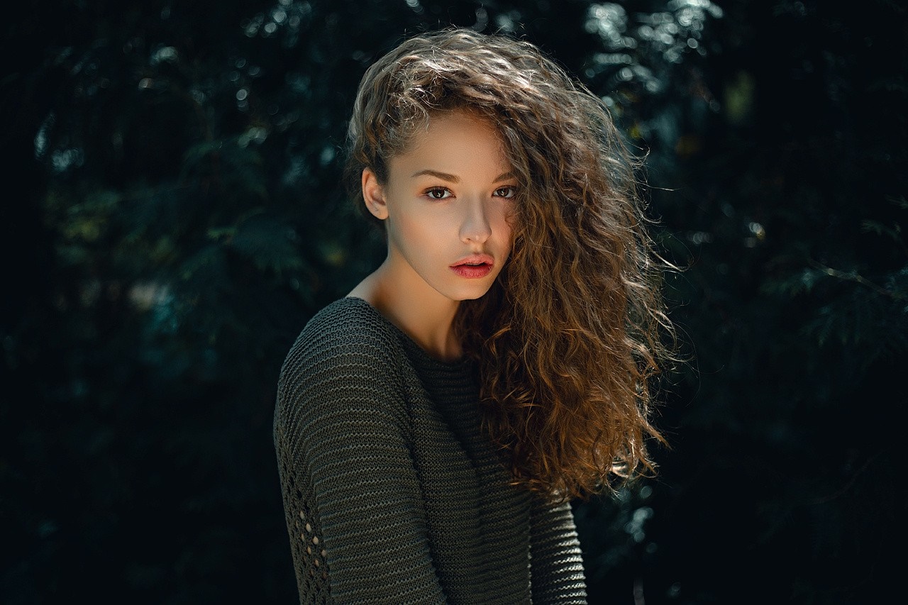 Woman with curly auburn hair wearing a sweater HD Wallpaper