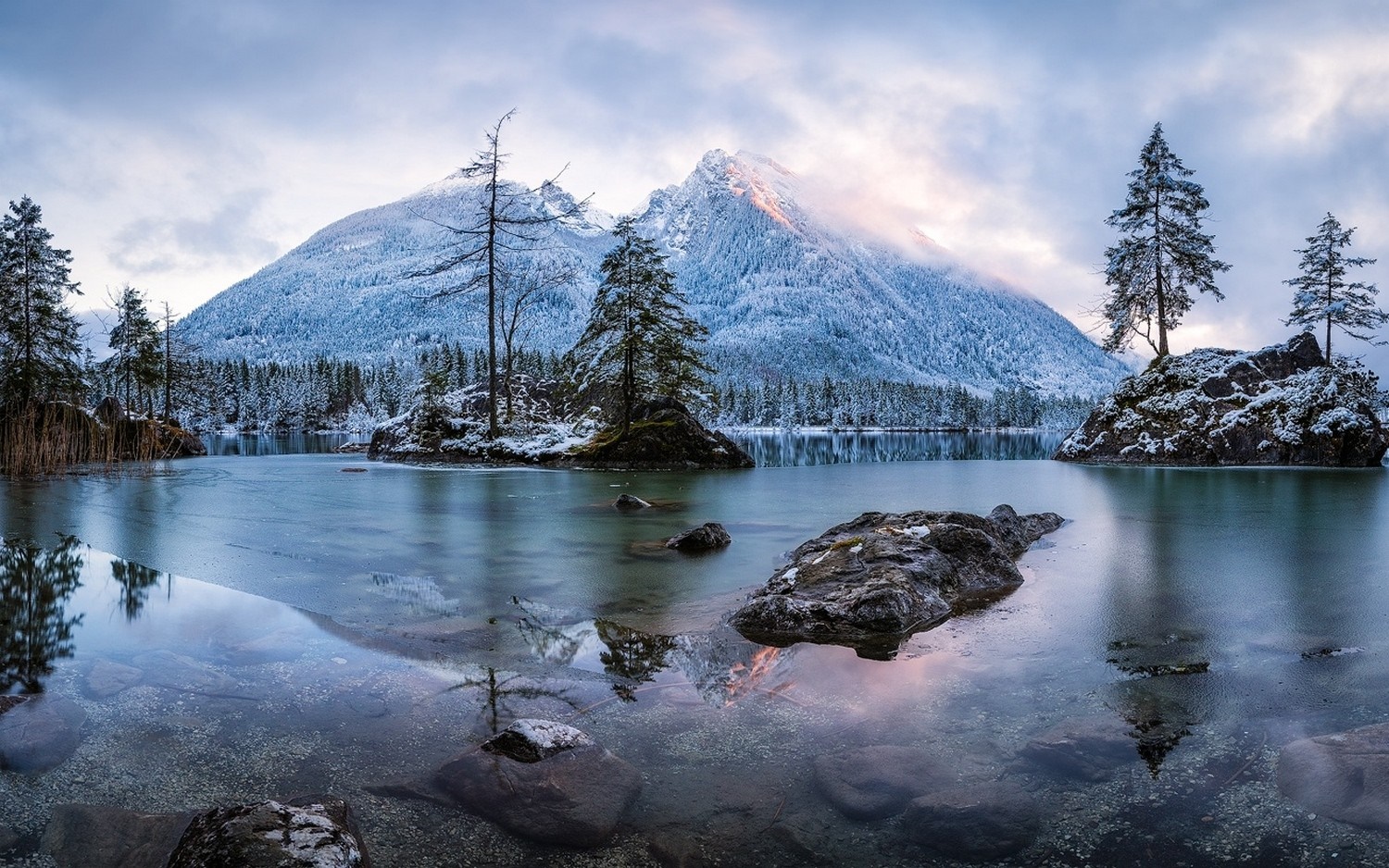 Snow-covered mountains reflected in a partially frozen lake HD Wallpaper