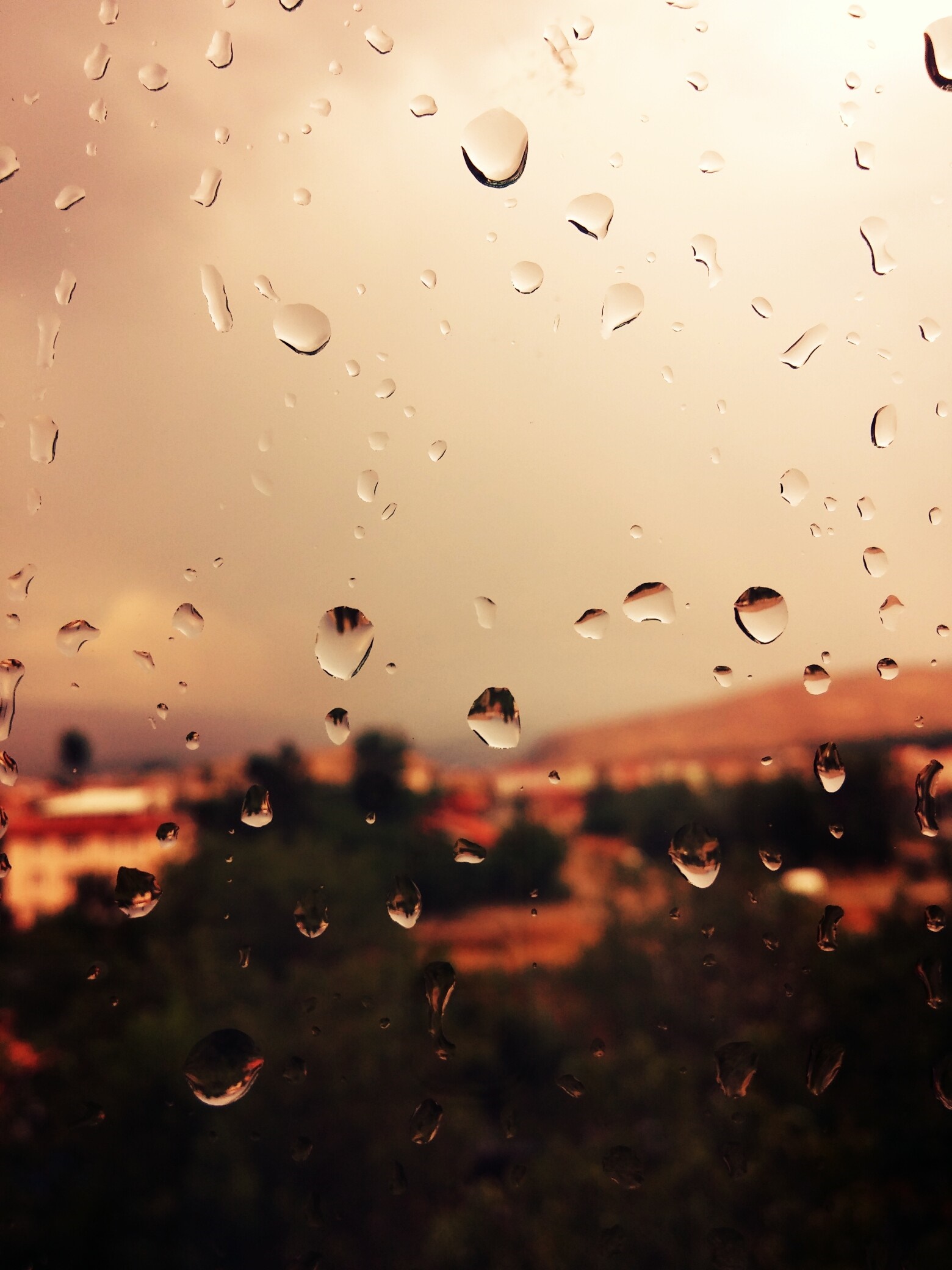 Raindrops on a window overlooking a blurred town HD Wallpaper