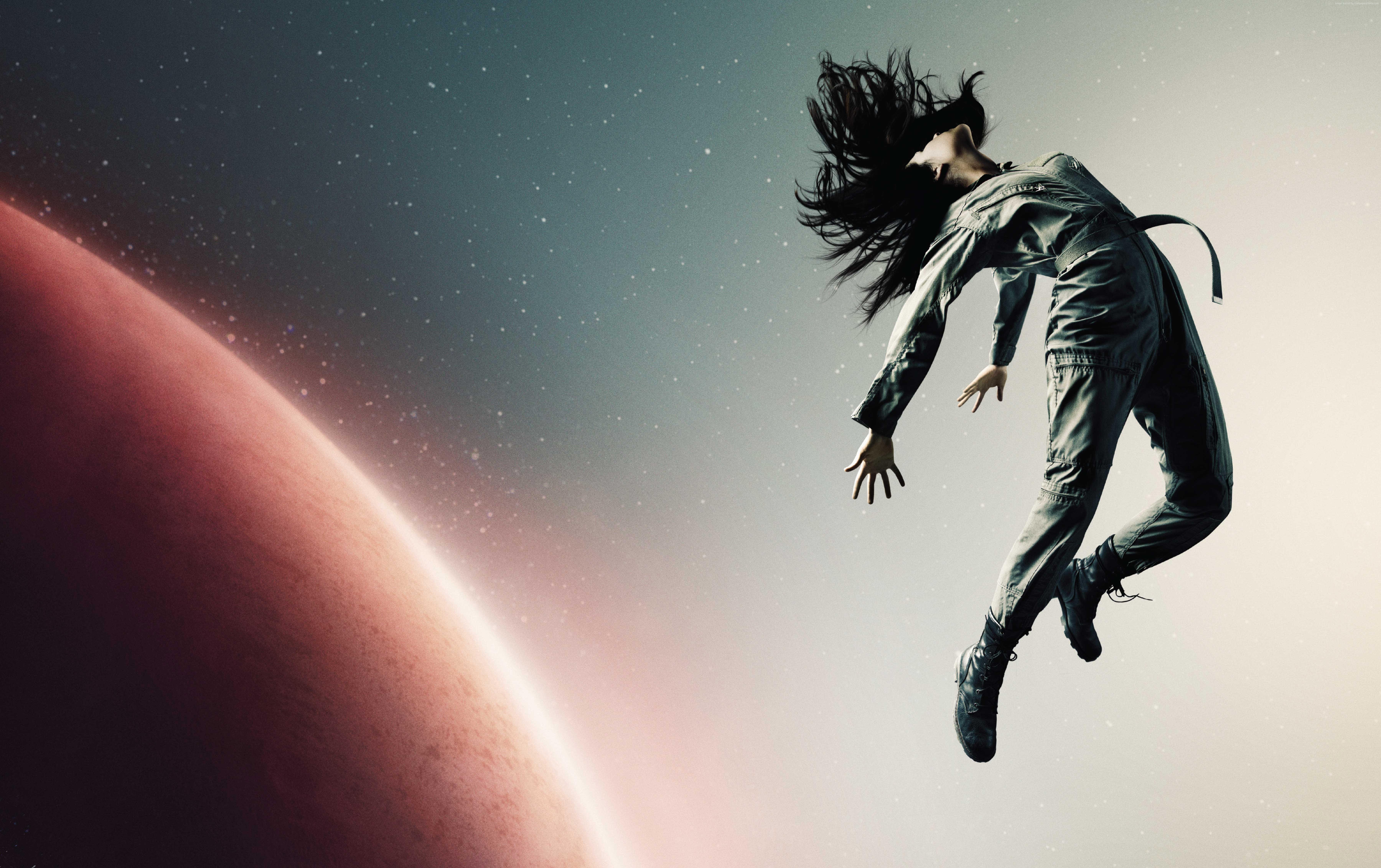 Woman in jumpsuit floating in space near a planet HD Wallpaper