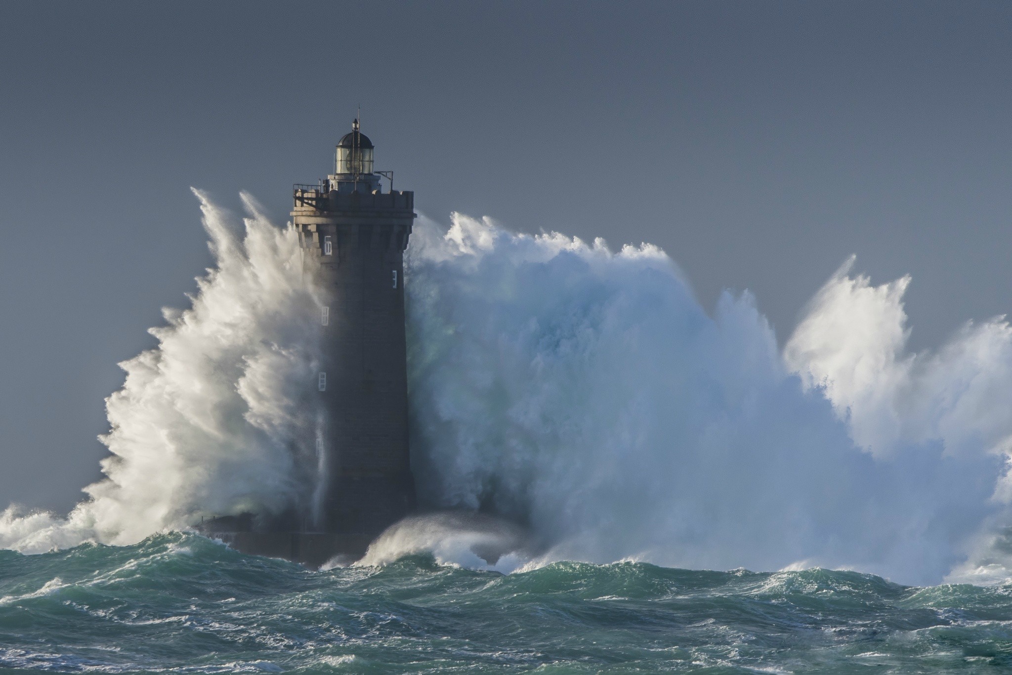 Lighthouse battered by massive ocean waves HD Wallpaper