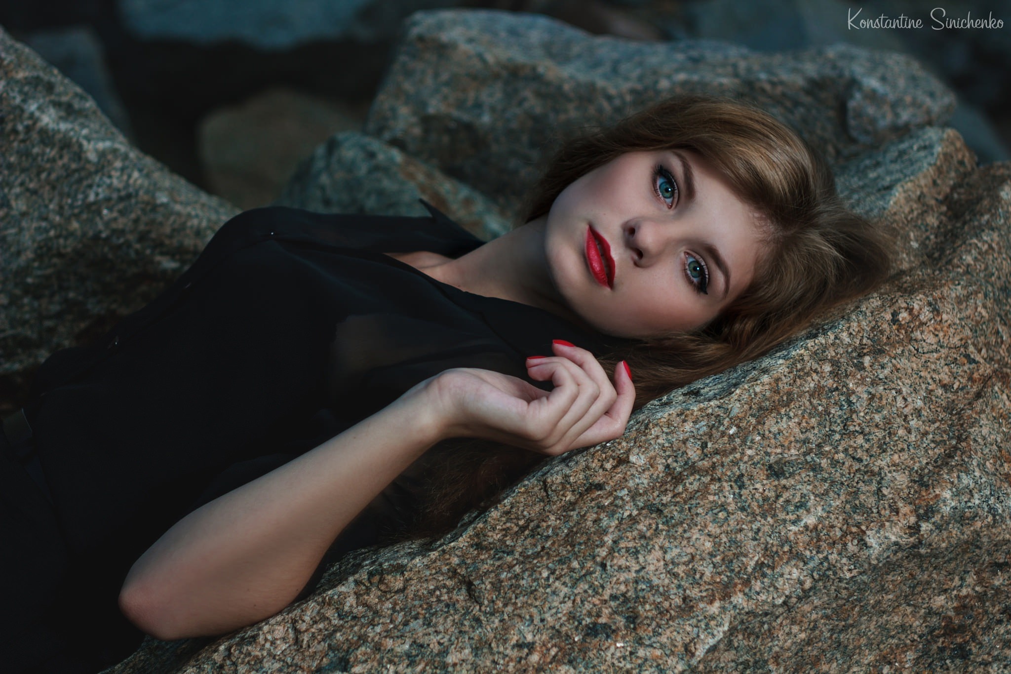 Woman with green eyes lying on rocks HD Wallpaper