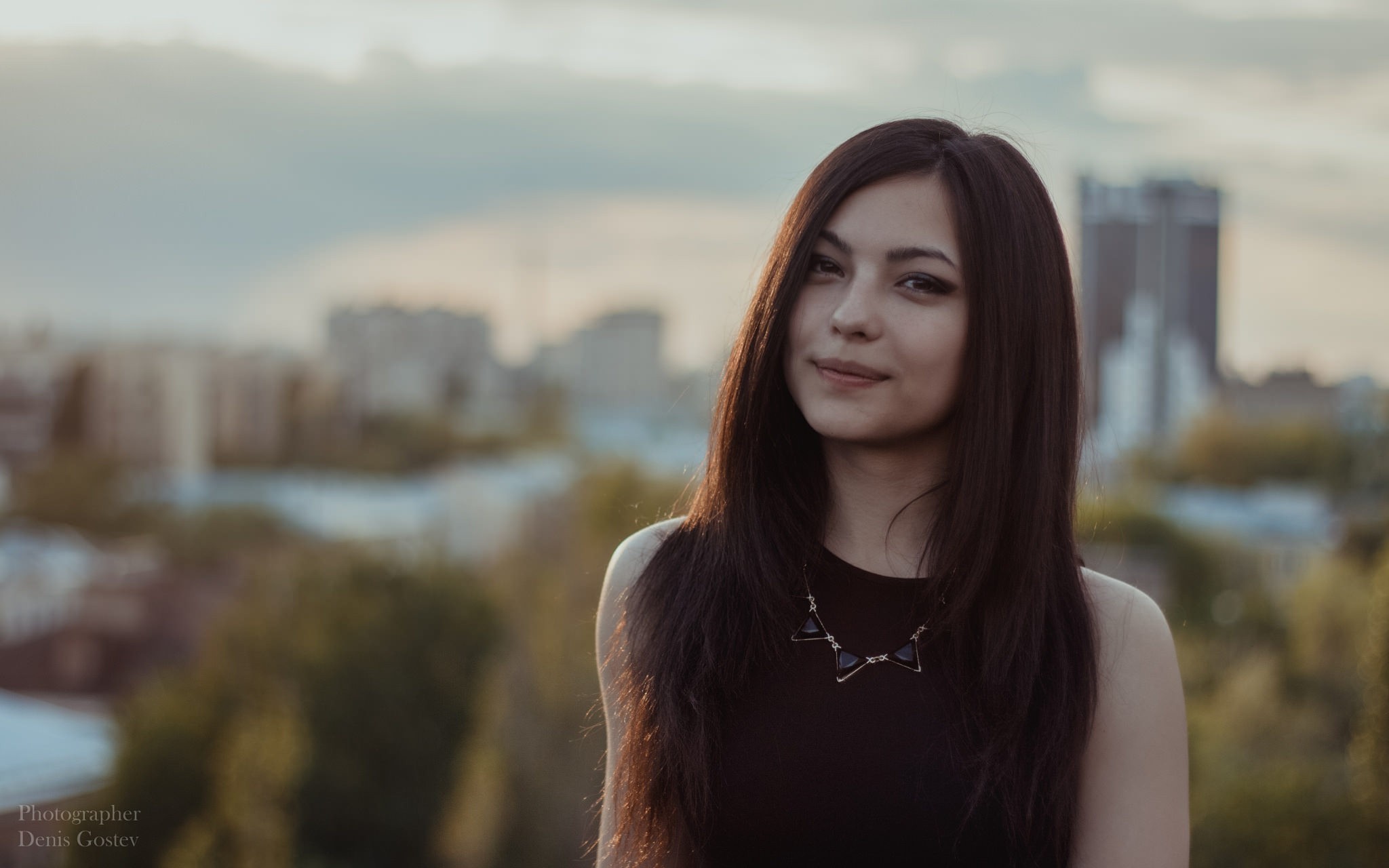 Woman with long brown hair wearing a black dress and necklace HD Wallpaper
