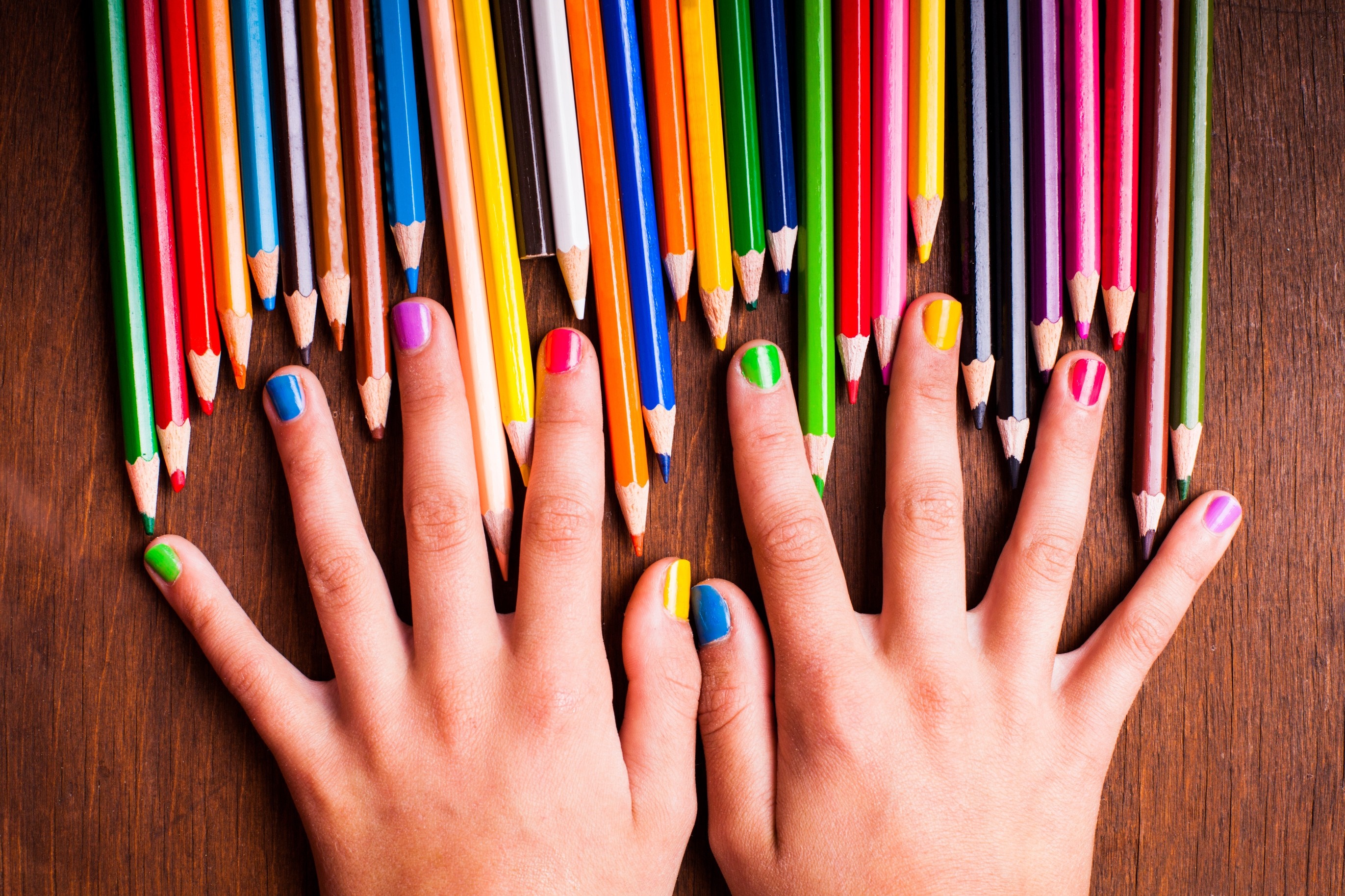 Hands with colorful nail polish and pencils HD Wallpaper