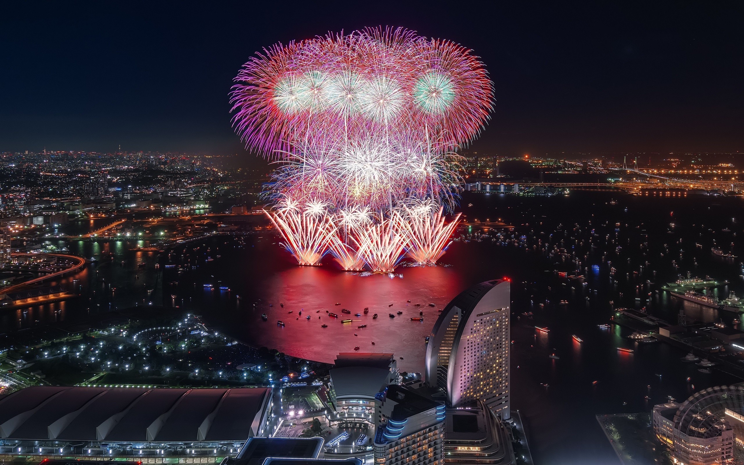 Fireworks over a city at night HD Wallpaper