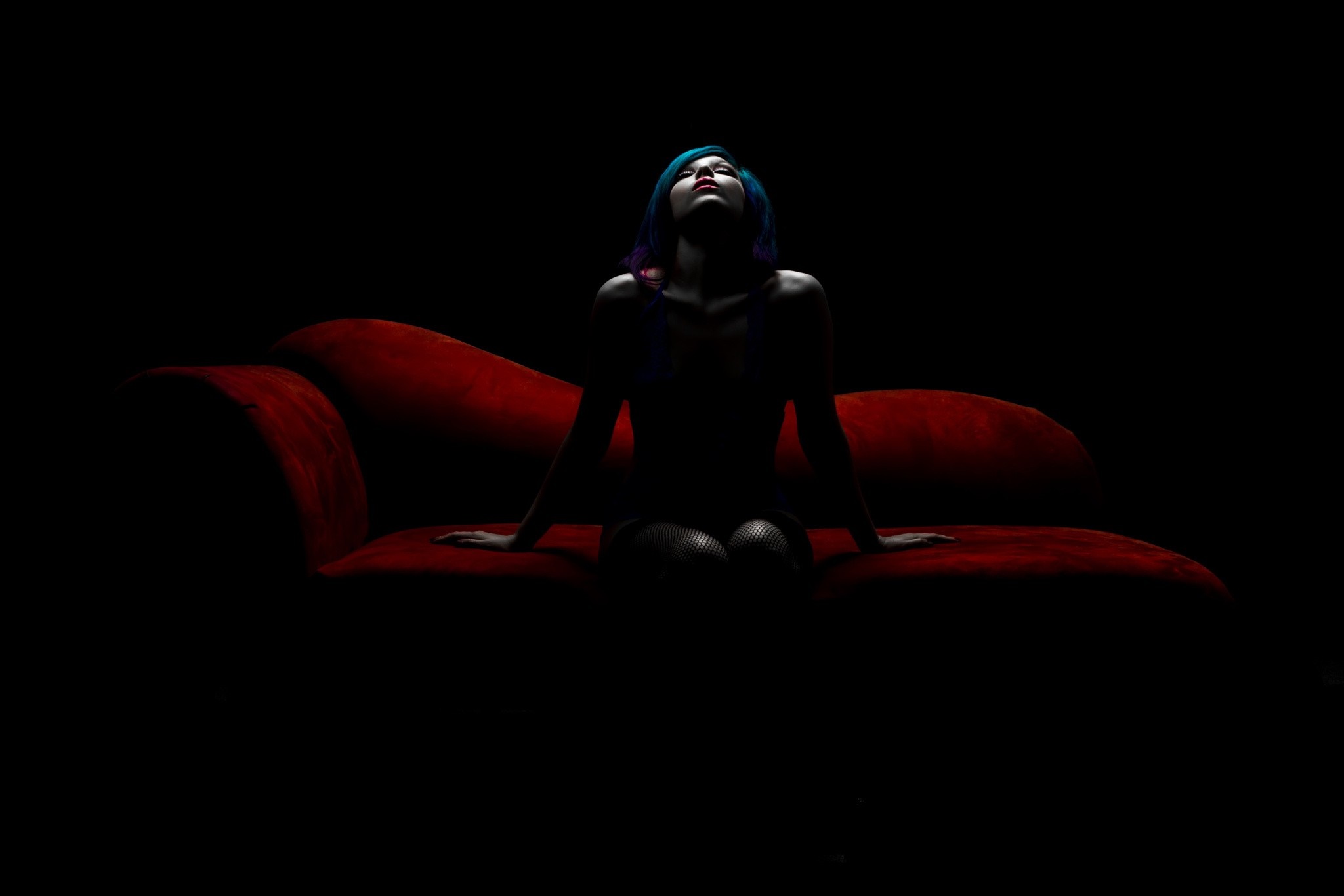 Woman with blue hair on a red couch HD Wallpaper
